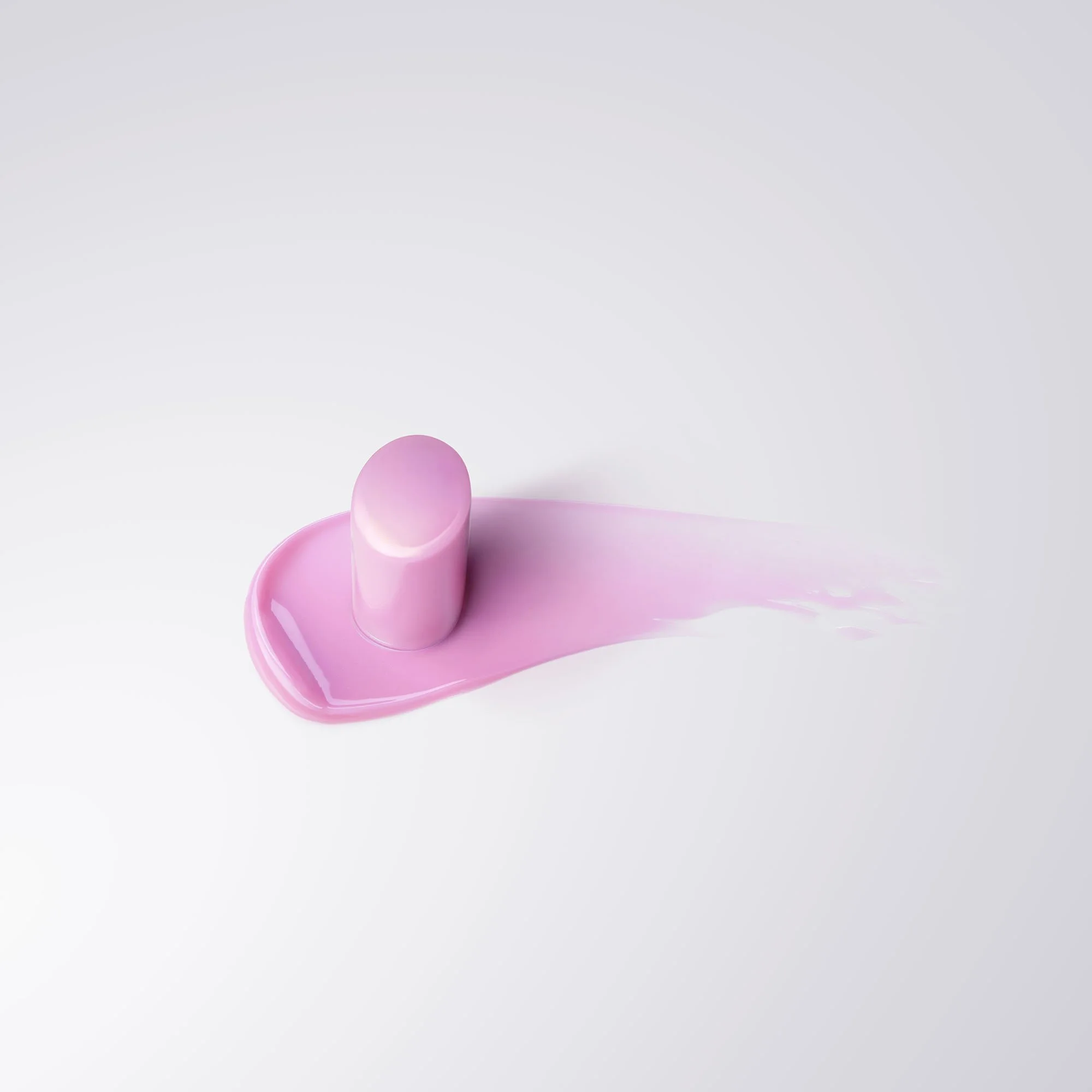 A few pink and purple capsules spilling onto a white surface.