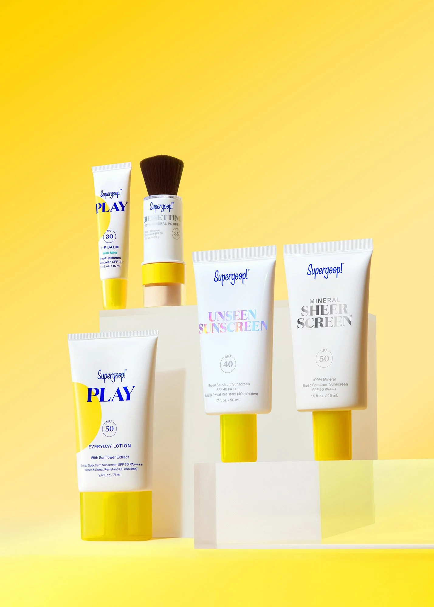 A collection of sunscreen and skincare products with yellow accents on a yellow background.