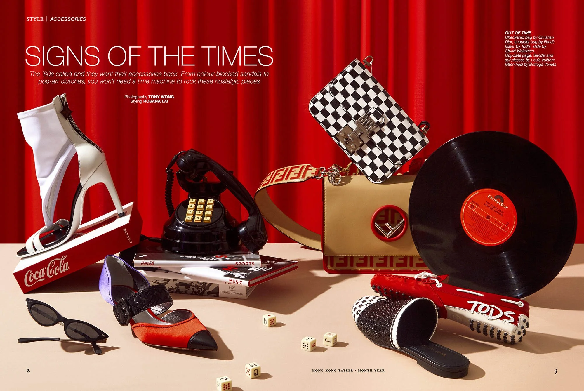 Fashion accessories on a table with a red velvet curtain background, including a white high-heeled shoe on a Coca-Cola box, a vintage black rotary telephone, a pair of black sunglasses, a red and black high-heeled shoe, a checkered handbag, a vinyl r