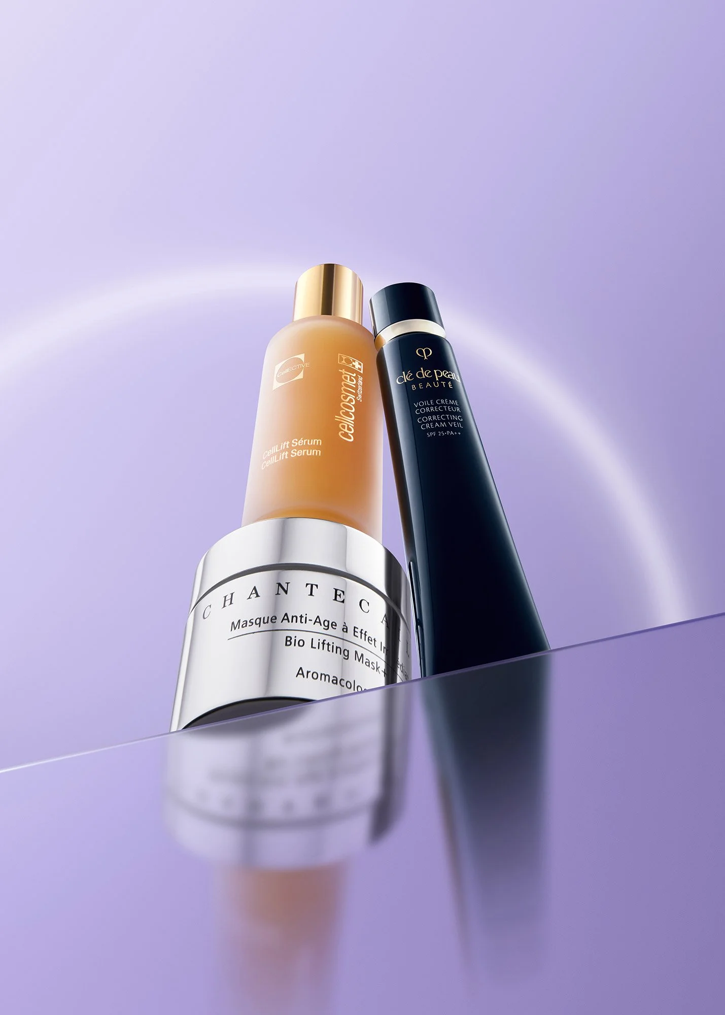 Three skincare products displayed on a lavender surface against a lavender background with a soft glow.