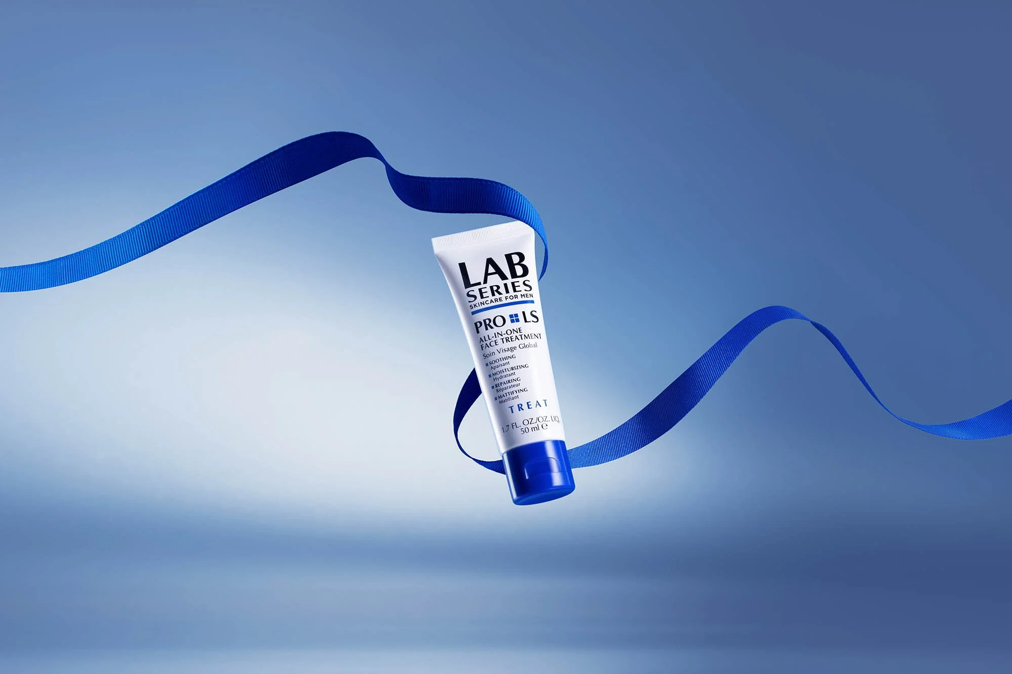 A tube of LAB Series Pro LS All-in-One Face Treatment surrounded by a blue ribbon on a blue gradient background.