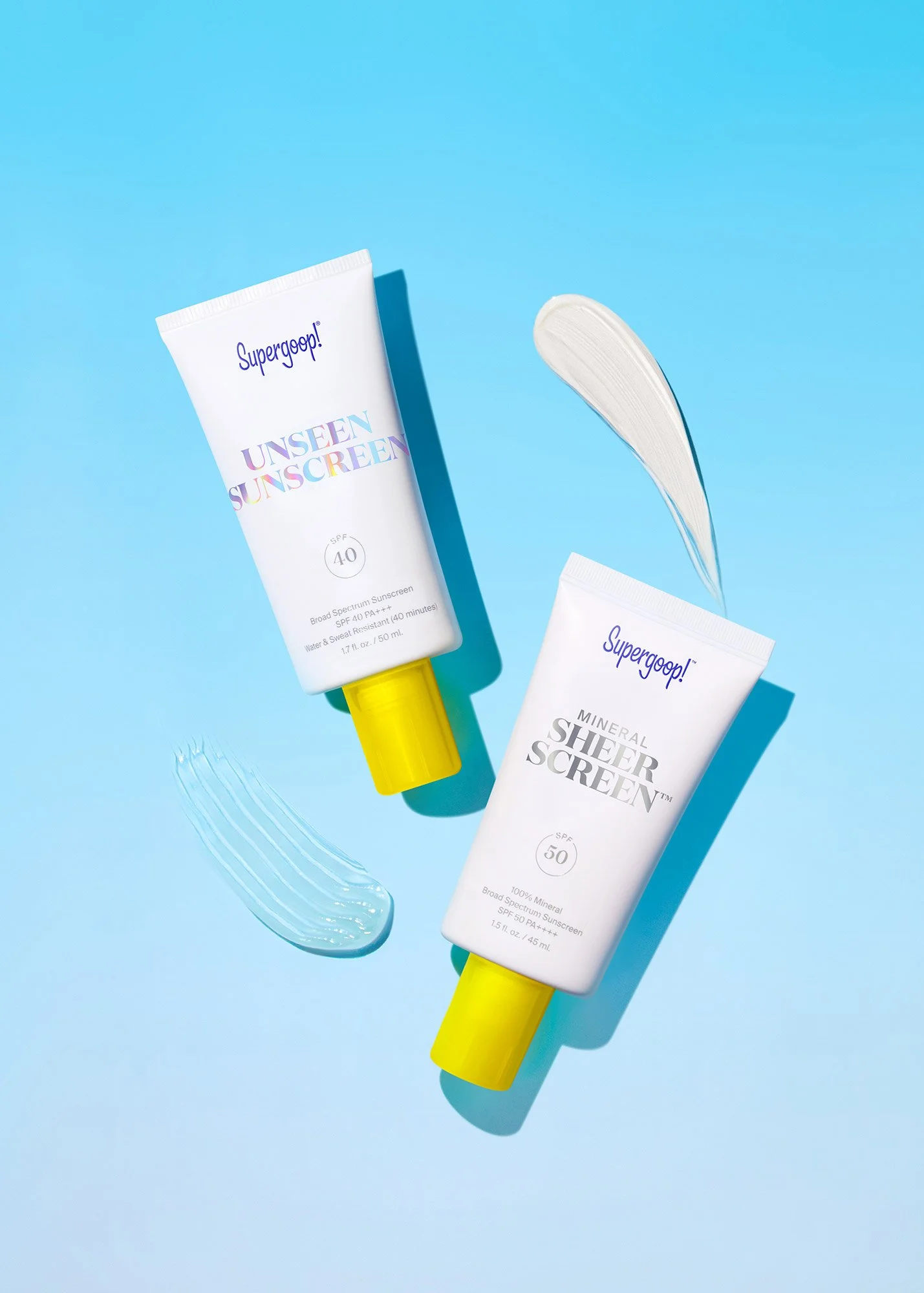 Two tubes of sunscreen, one labeled "UNSEEN SUNSCREEN SPF 40" and the other labeled "MINERAL SHEER SCREEN SPF 50," with blobs of white sunscreen and swatches on a blue background.