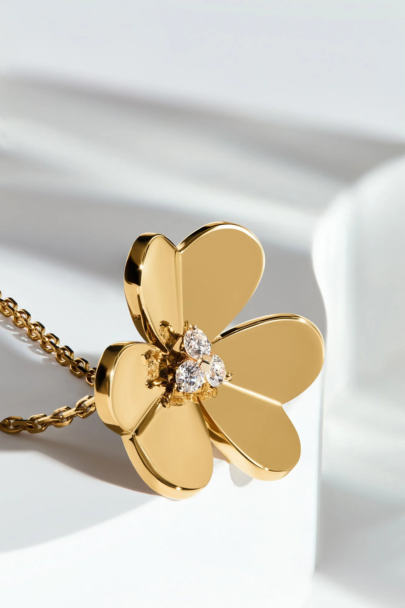 Gold butterfly necklace with diamond accents on a white surface.