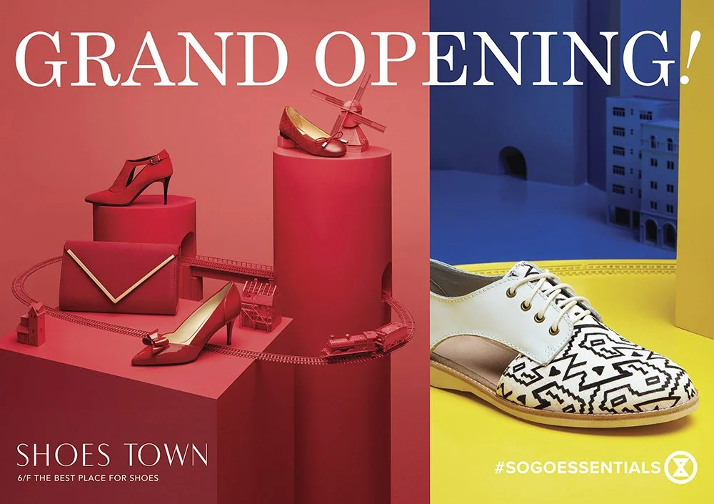 The image is an advertisement for Shoes Town's grand opening. The left side features a red theme with various high-heeled shoes, a clutch, and miniature train models, set against a pink background. The right side displays a pair of patterned sneakers