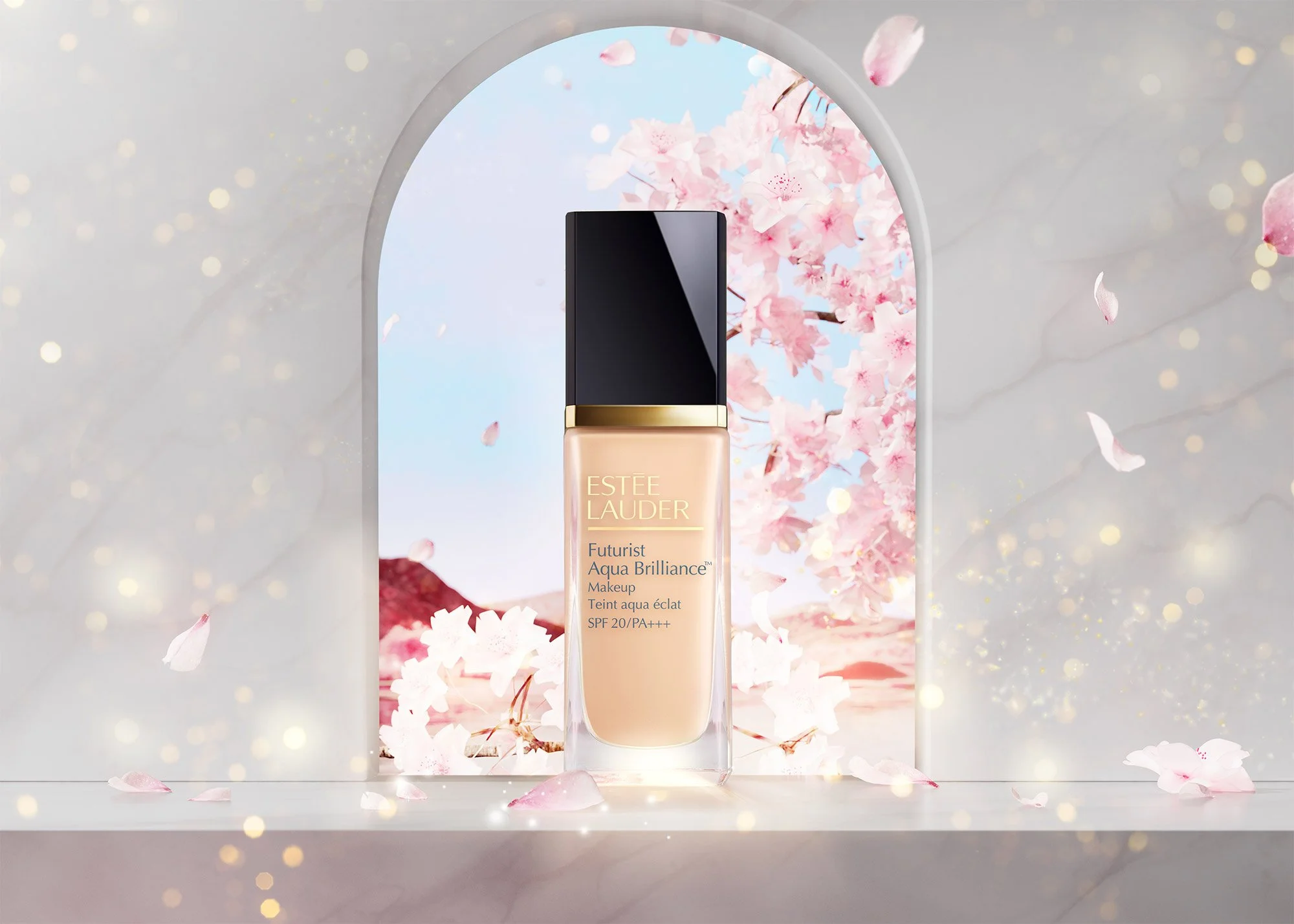 A bottle of Estée Lauder Futurist Aqua Brilliance foundation with cherry blossom background and pink petals.