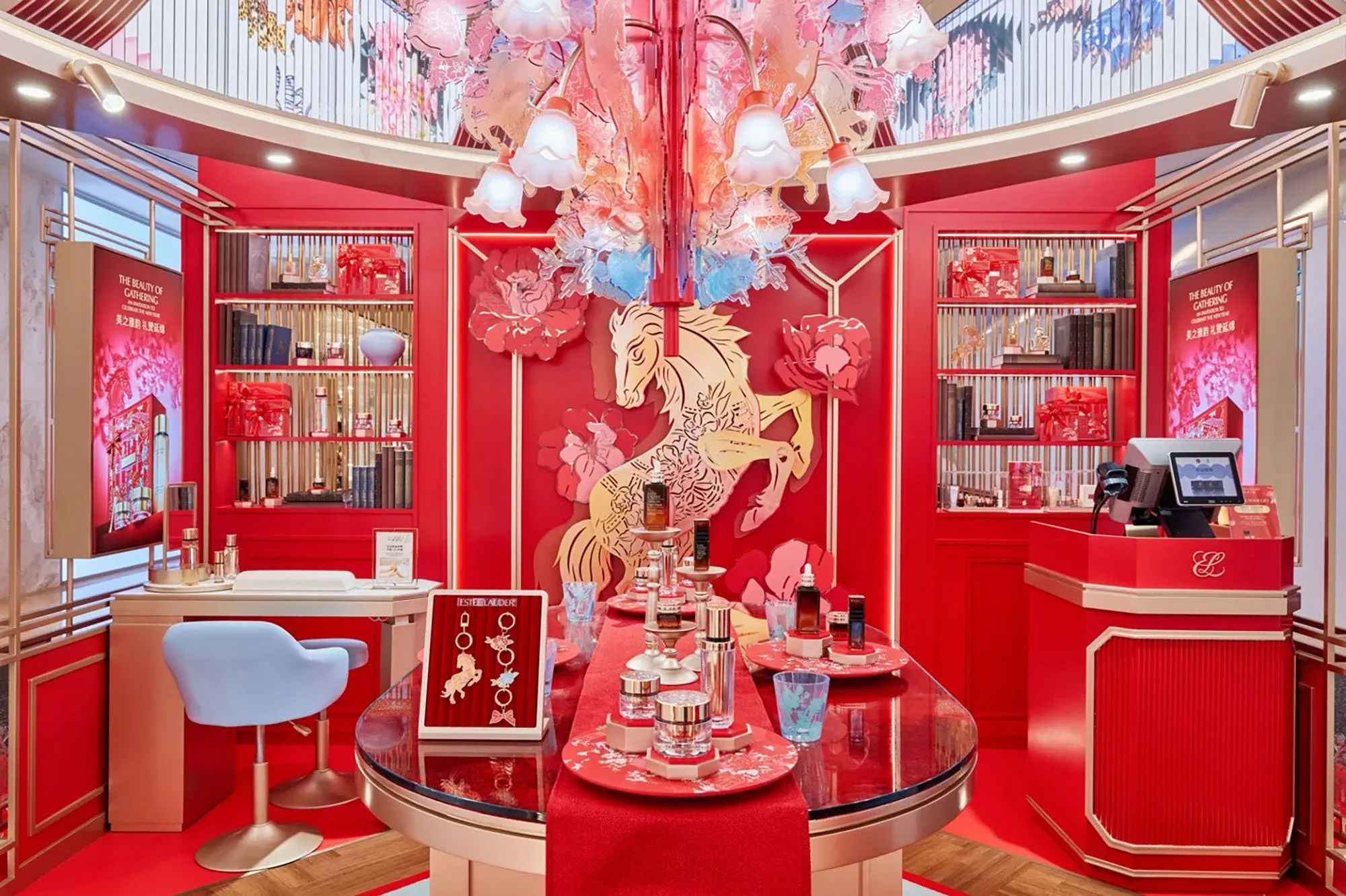 A colorful retail display with a red theme featuring a unicorn illustration and floral decorations, showcasing beauty products and jewelry.