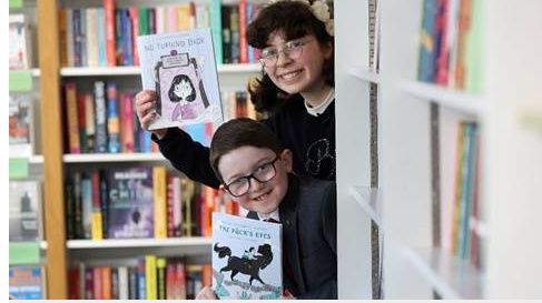 Specsavers Children’s Short Story Competition 2025 winners Charles and Esme receiving their illustrated books
