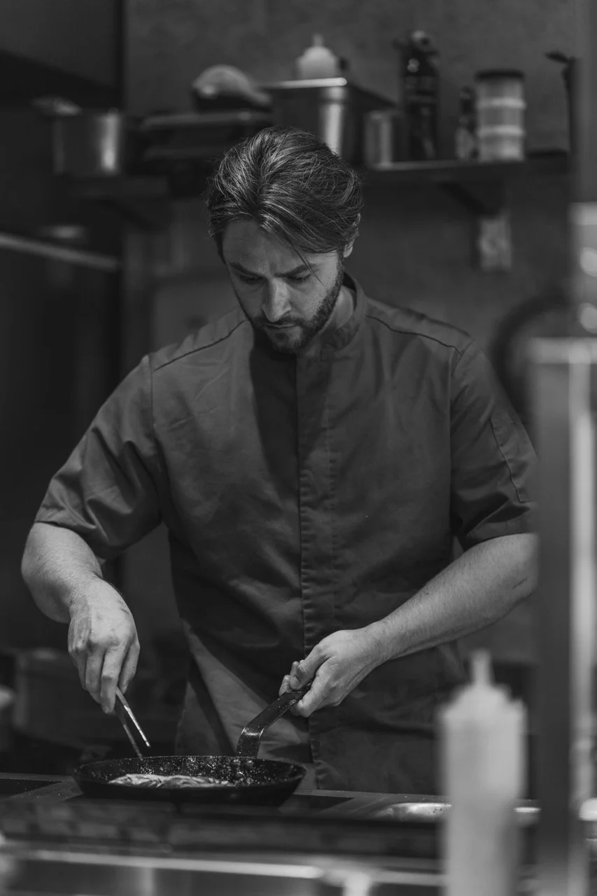 Chef in keuken met pan, zwart-wit foto