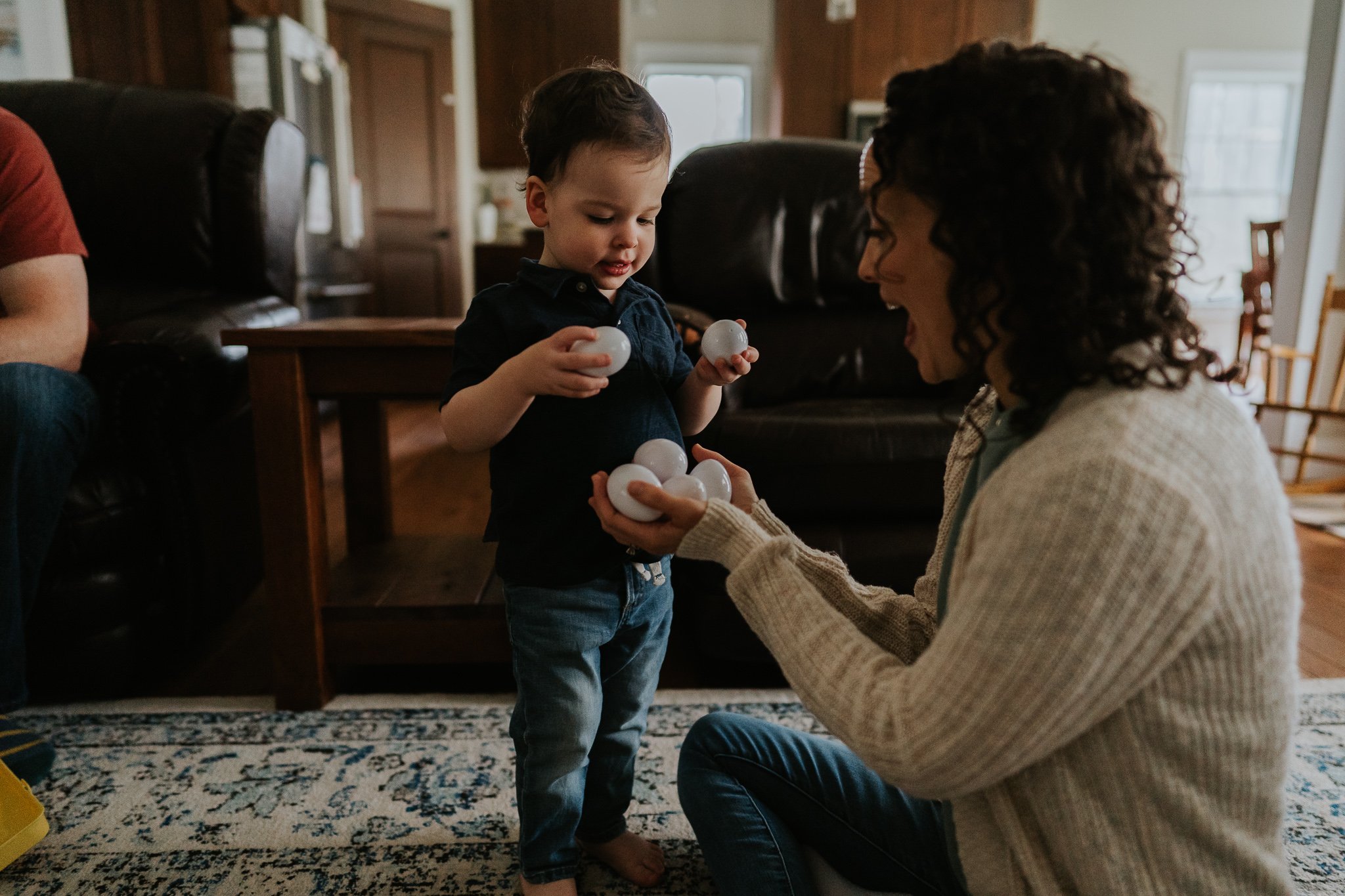 Mom Helping Toddler with Toy During Family Session