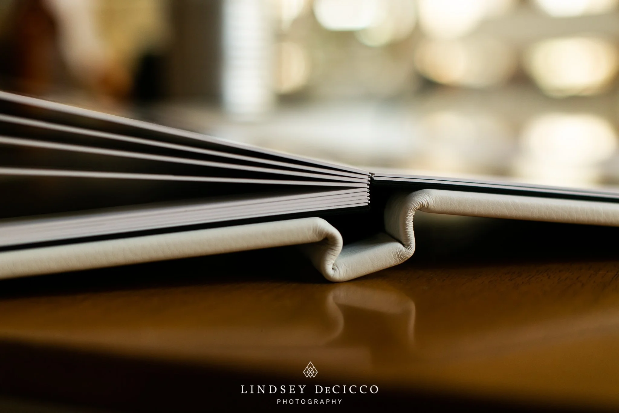 Close-up of a premium lay-flat family photo album on a table—professional photo book design included with South Bend family photographer sessions.