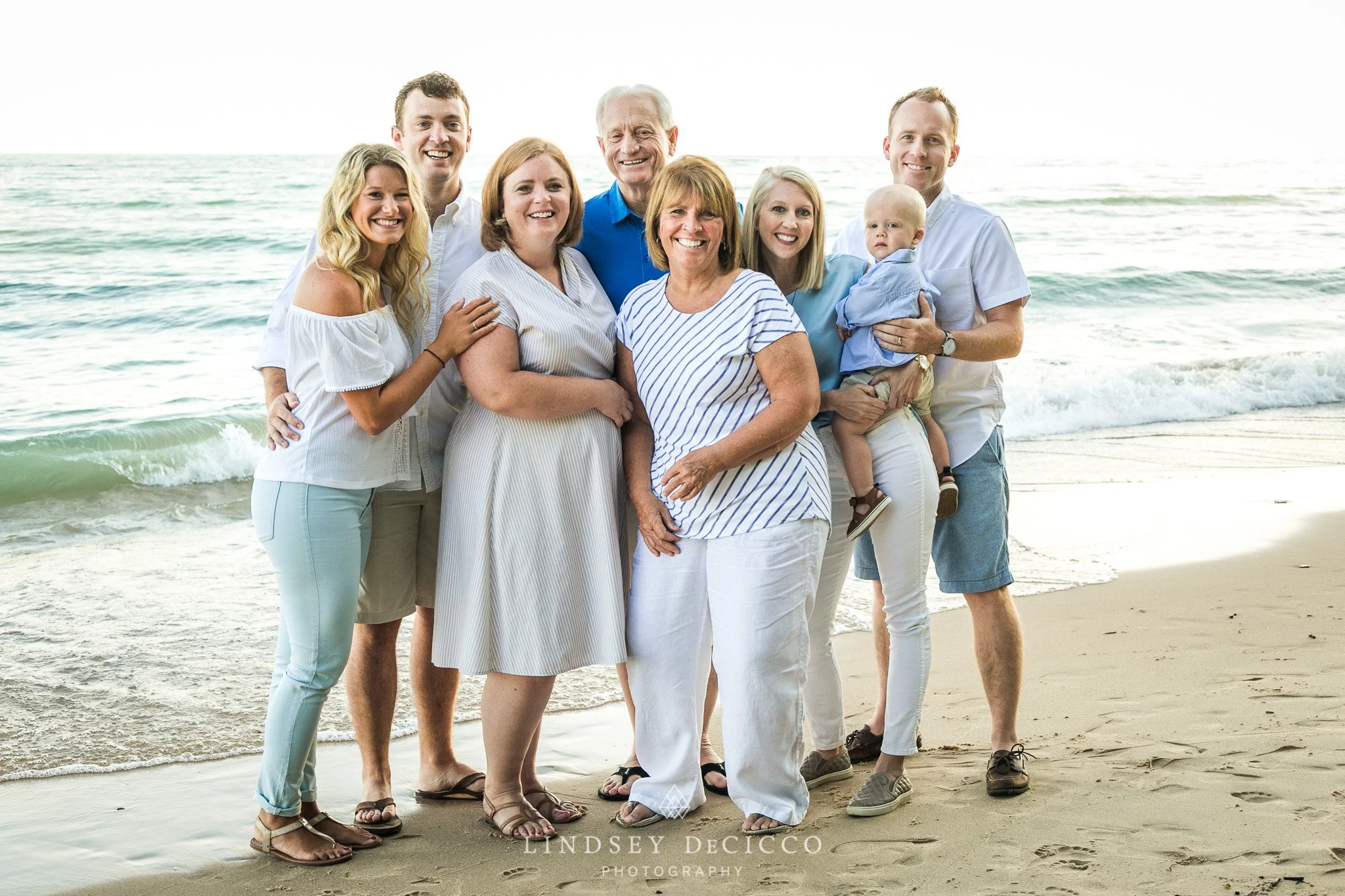Family portrait on the beach with waves in the background