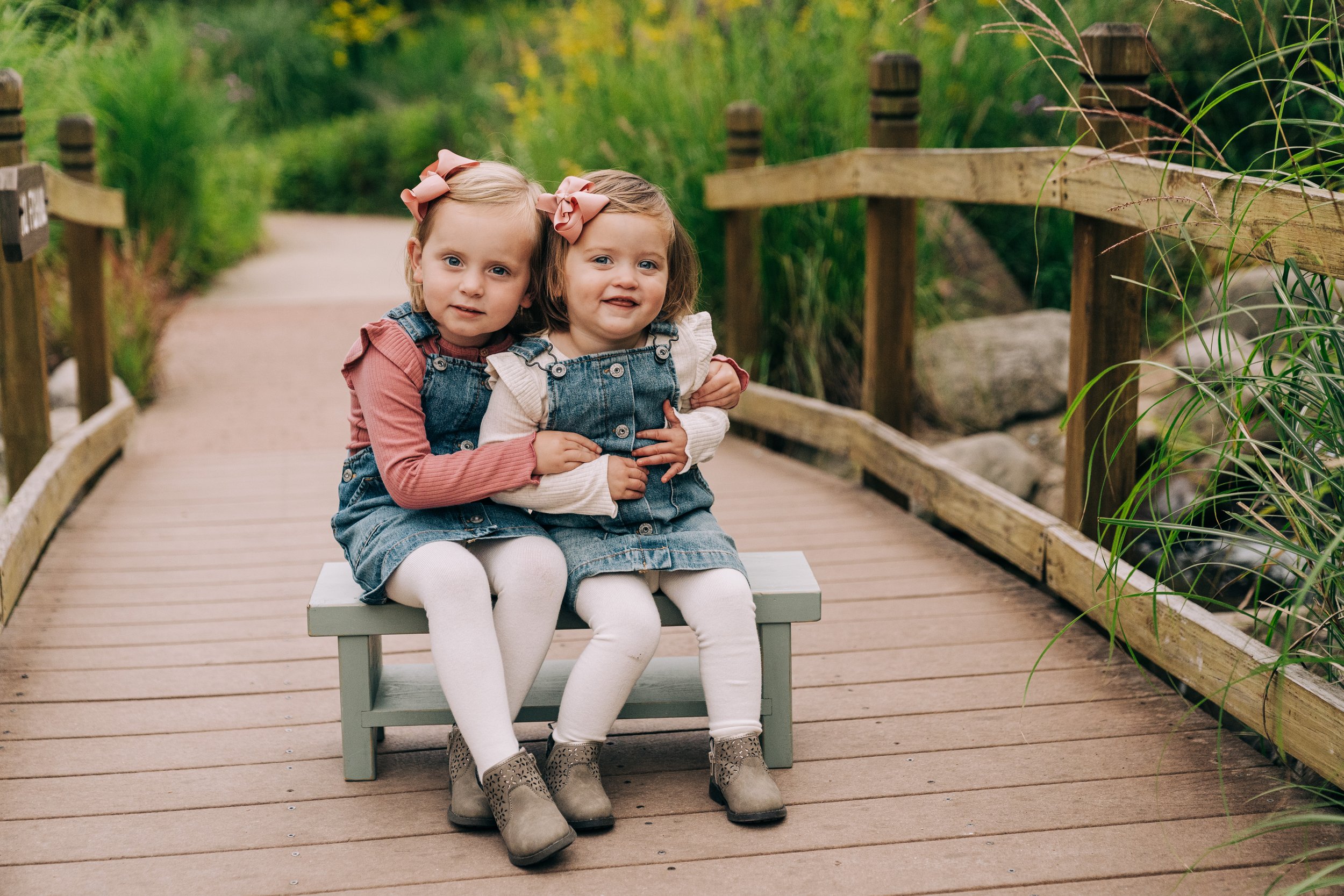 sisters sit on bench 
