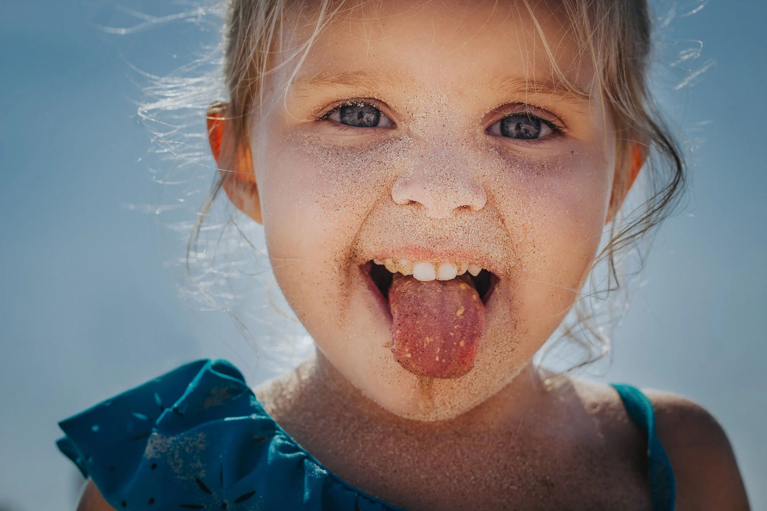 Little girl with sand all over her face