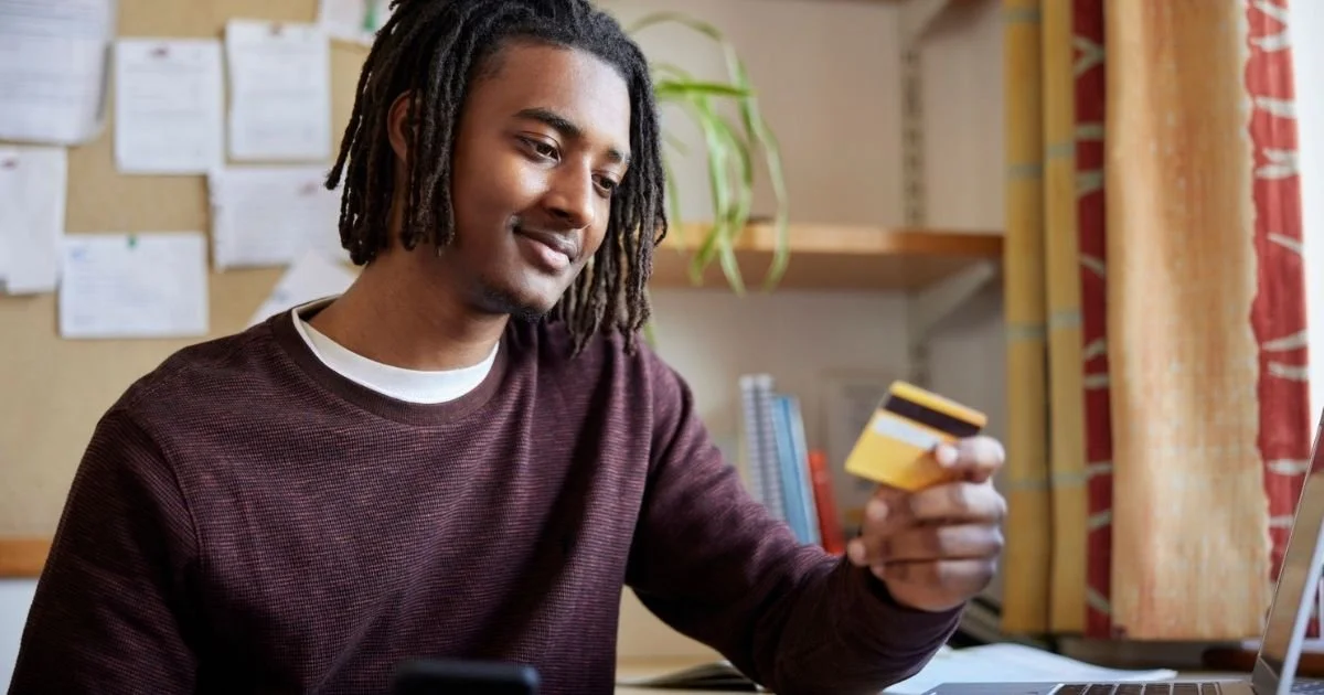 College student managing finances with a credit card and phone