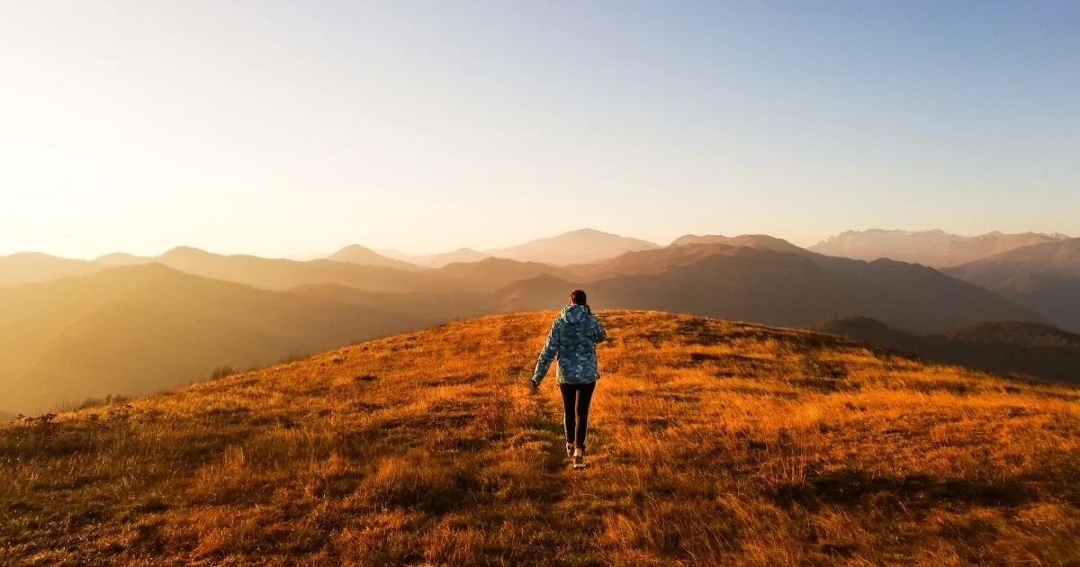 Woman hiking during fall sunrise
