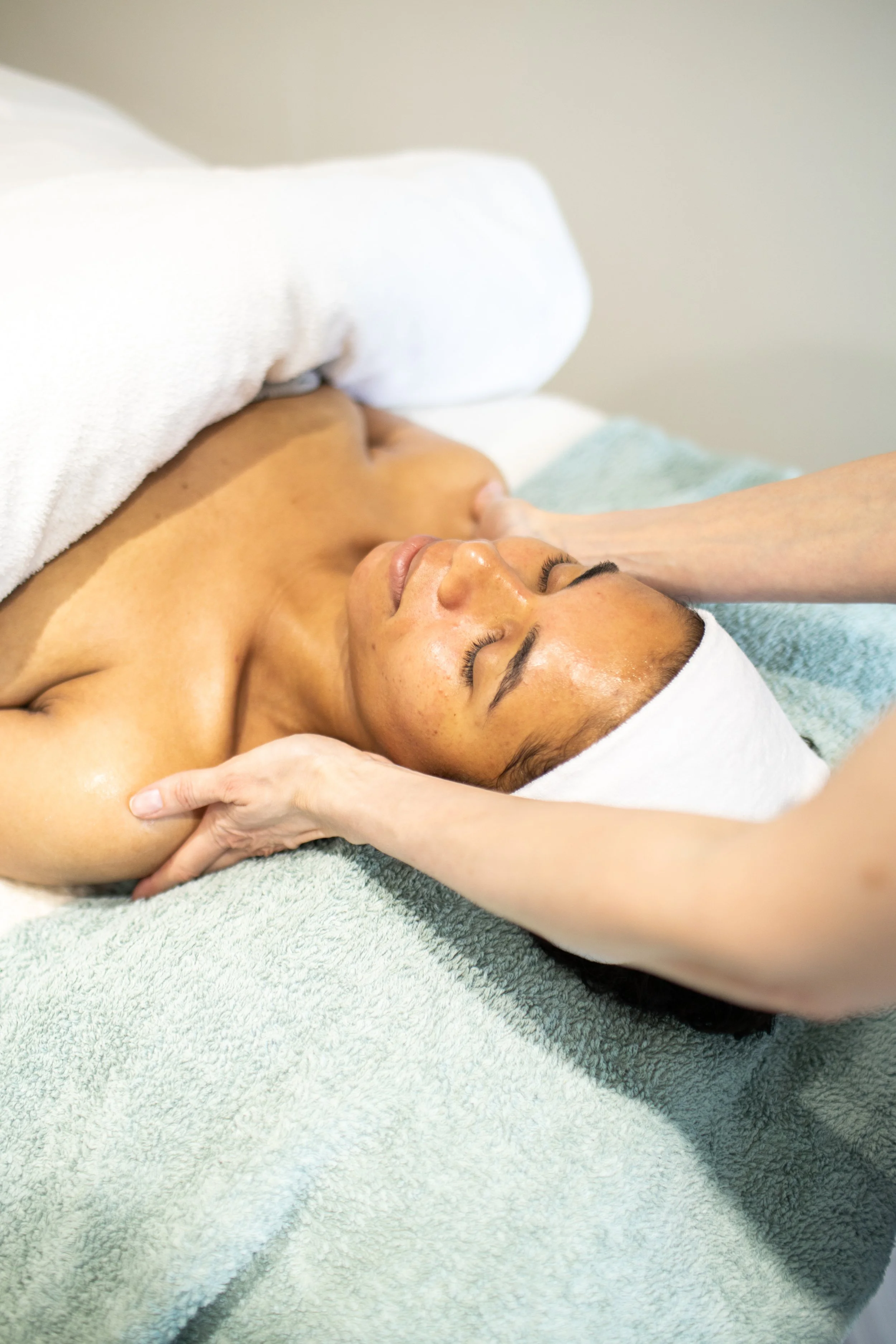 Woman on treatment bed having facial