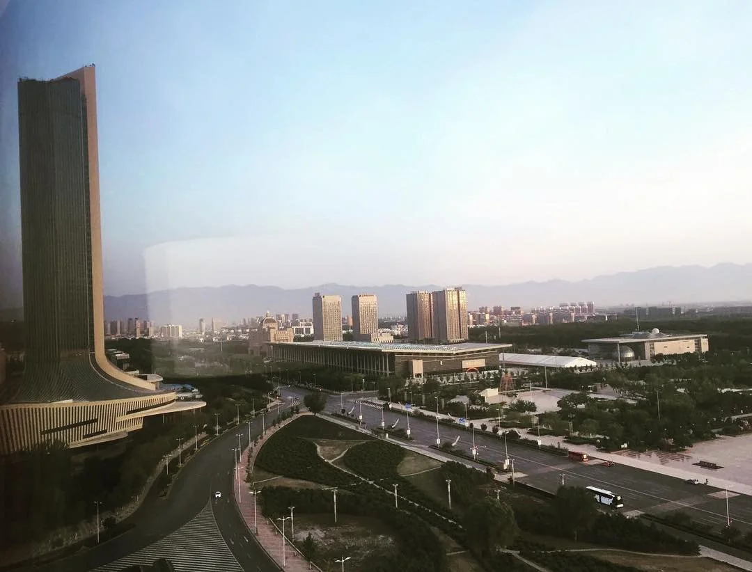 A serene Sunday sunrise over city and Helan Mountains.