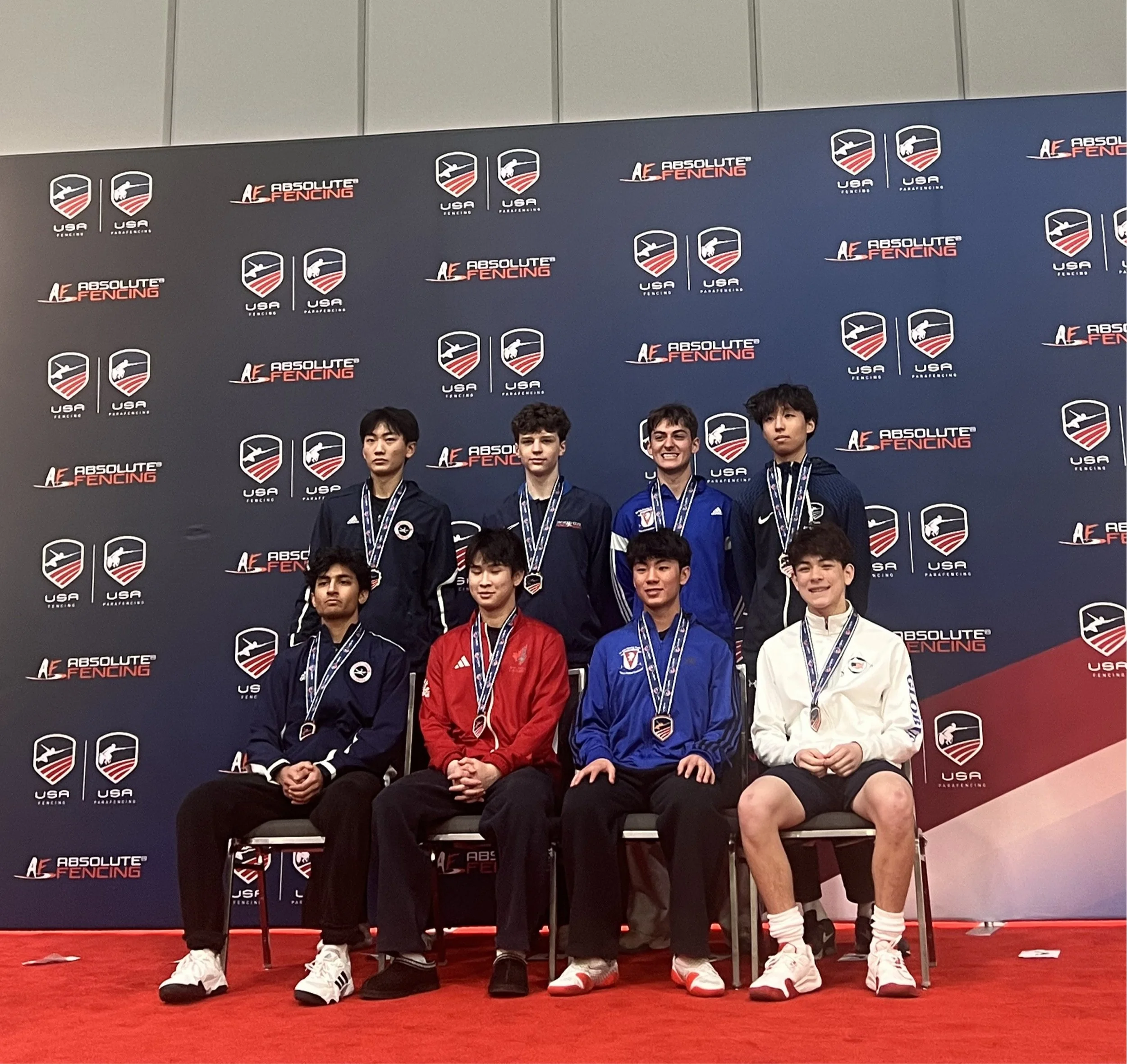 Group of male fencing athletes on the podium holding medals and certificates at the 2025 Summer Nationals in Milwaukee, Wisconsin.