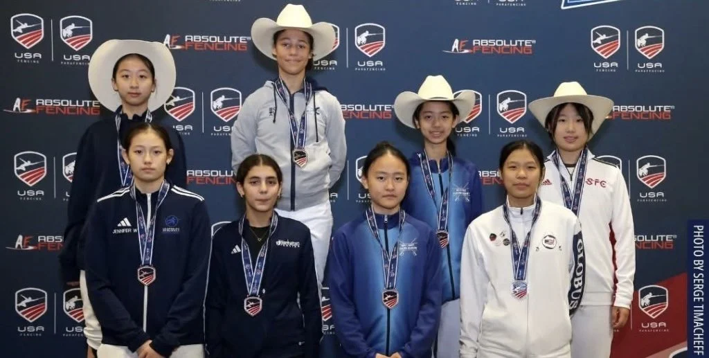 Group of male fencing athletes on the podium holding medals and certificates at the 2025 Summer Nationals in Milwaukee, Wisconsin.