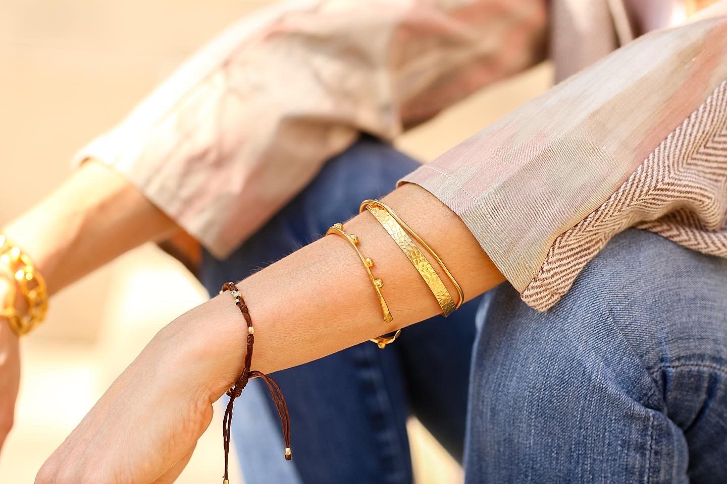 Woman wearing several gold bracelets