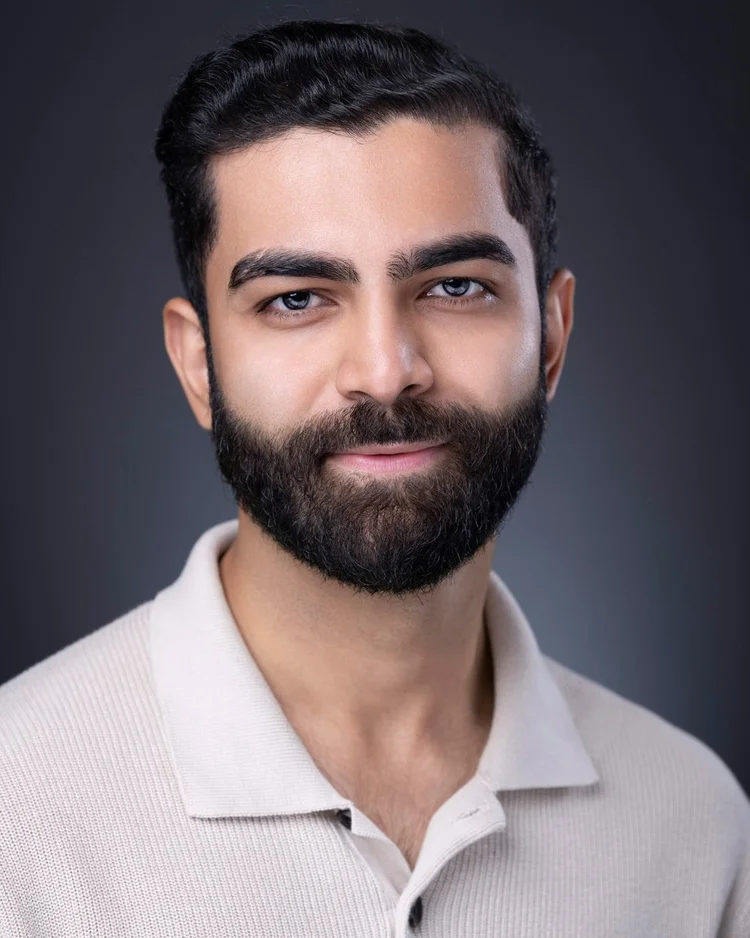 Man in a cream polo against a dark gray background