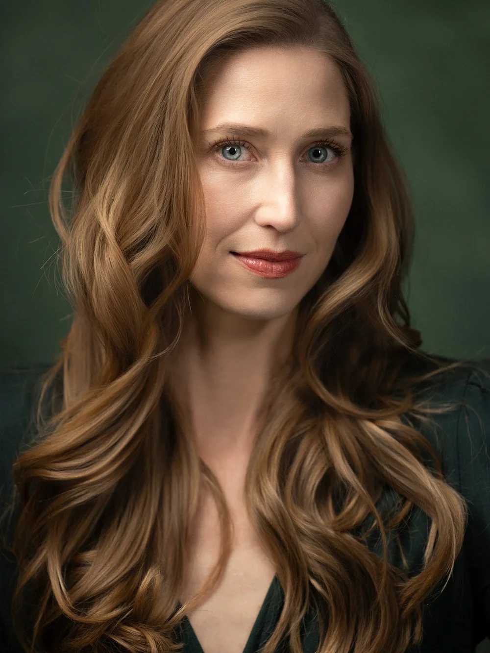 Close portrait of Amanda against a deep green background