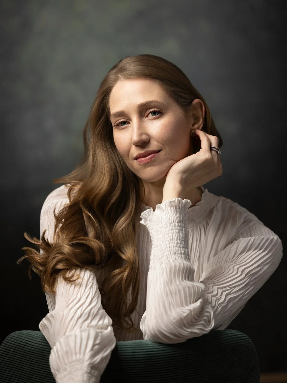 Amanda seated in a white textured blouse in the studio