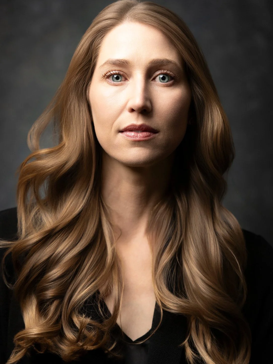 Theatrical female actor headshot against a dark gray background