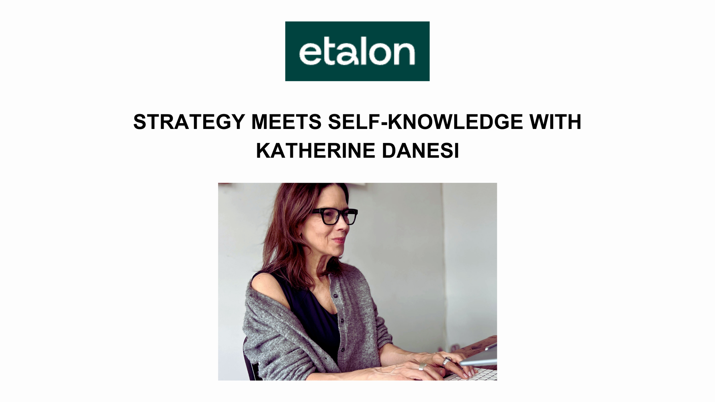 Woman seated at a desk typing on a laptop