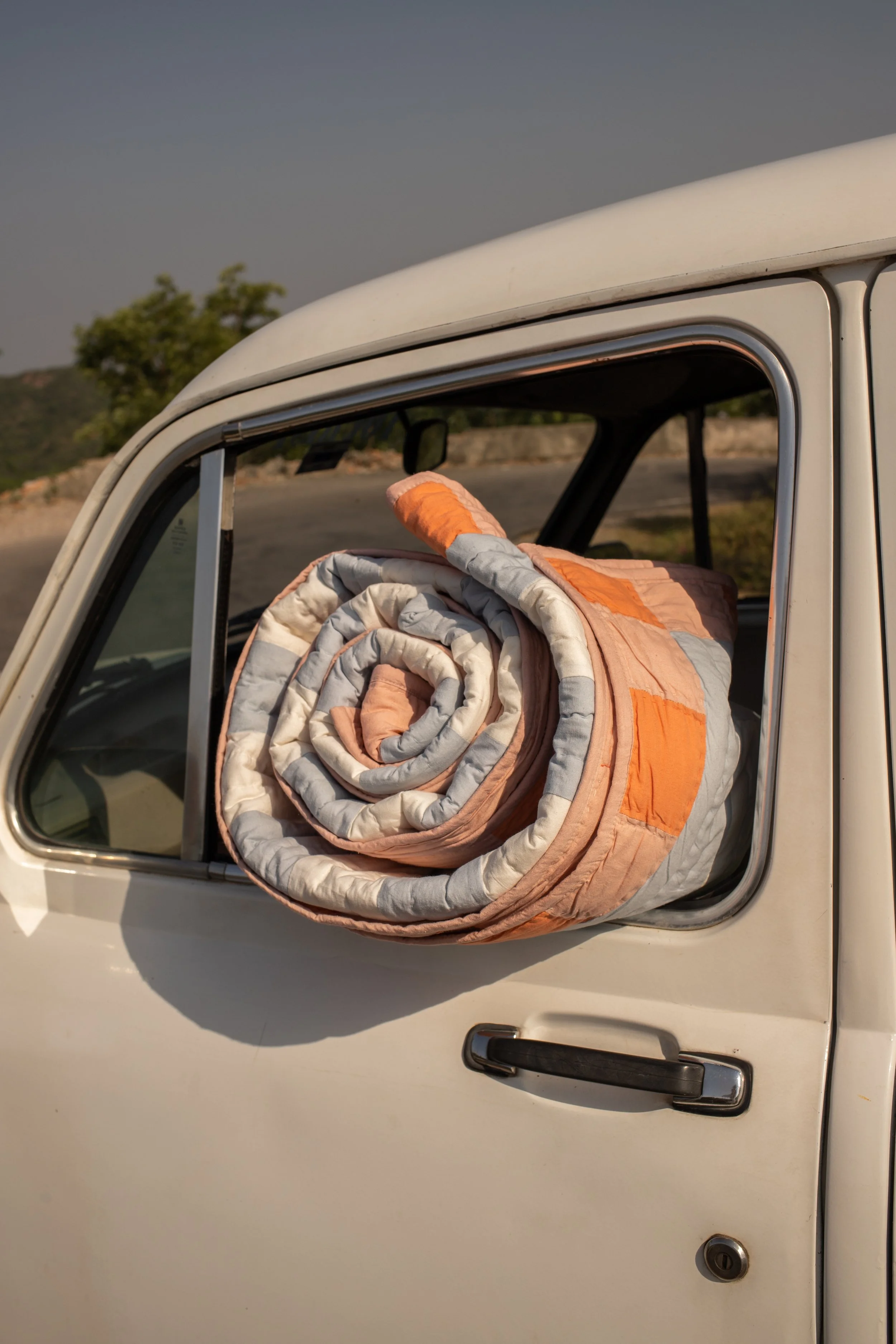 Shivani Quilt bundled up in a vintage car in Jaipur.