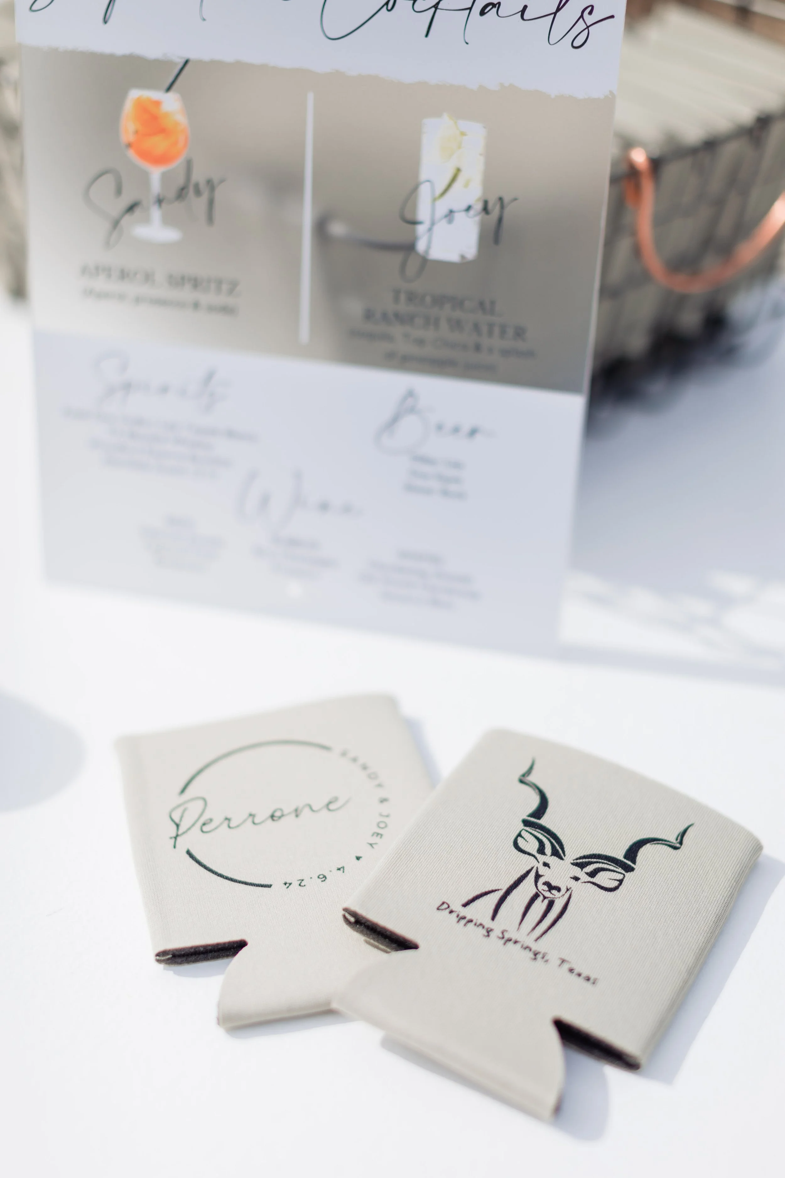 Menu with tropical cocktails, and two beige cards, one with a logo and the name Perrone, and the other with a drawing of a gazelle and the text Daring Spring Tear.