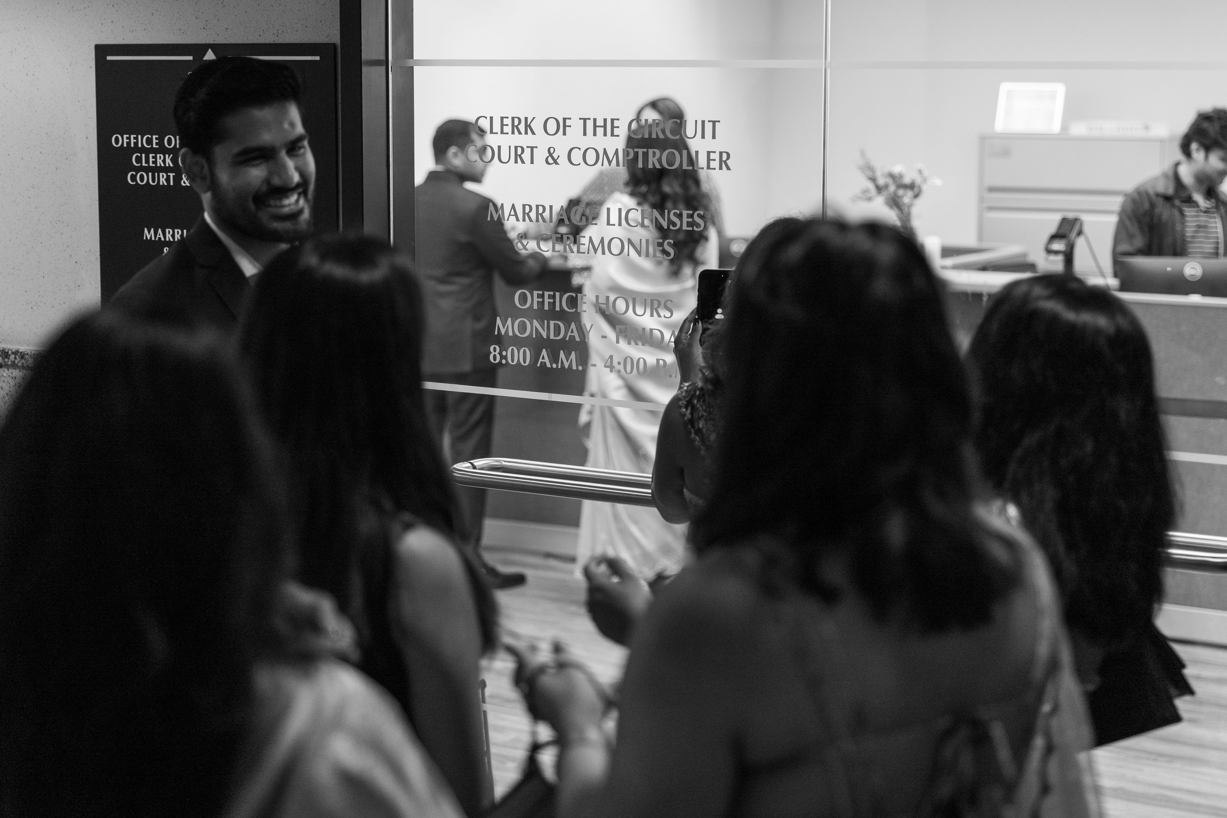 Couple and guests waiting near the marriage licenses office inside the West Palm Beach Courthouse before their wedding ceremony