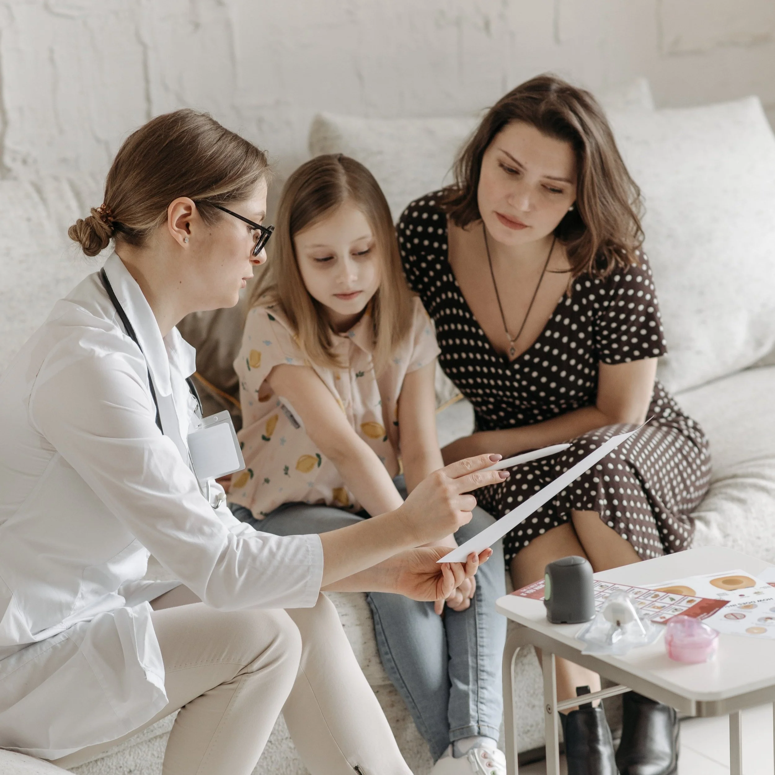 Female clinical provider interacting with child and mother on sleep treatments