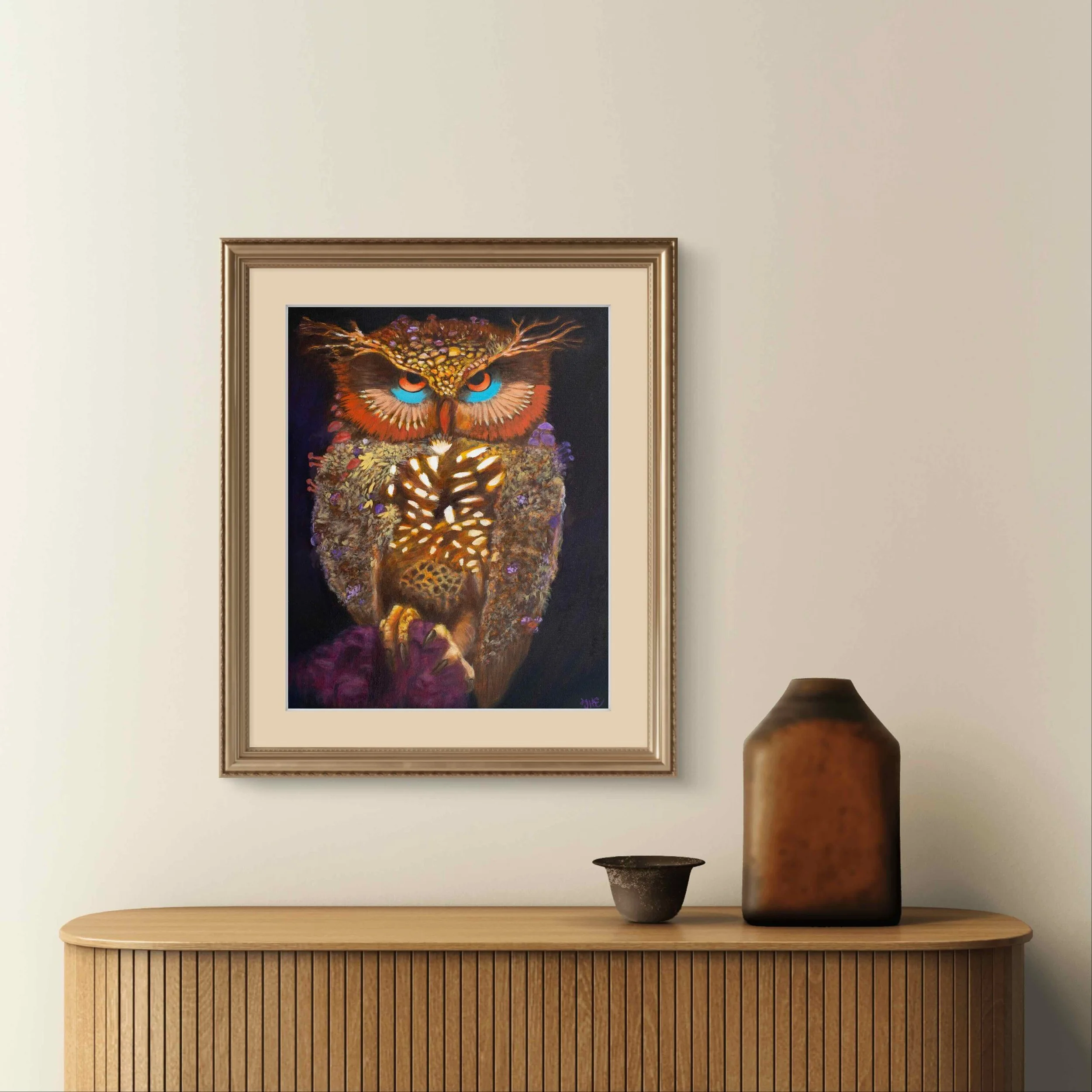 Owl artwork in a frame displayed above a wooden console in a neutral room.