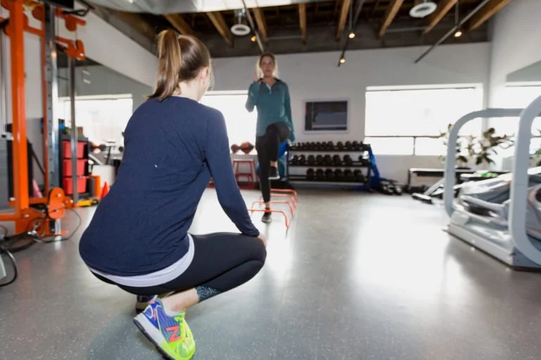 a physiotherapist leading running-specific exercises for a runner