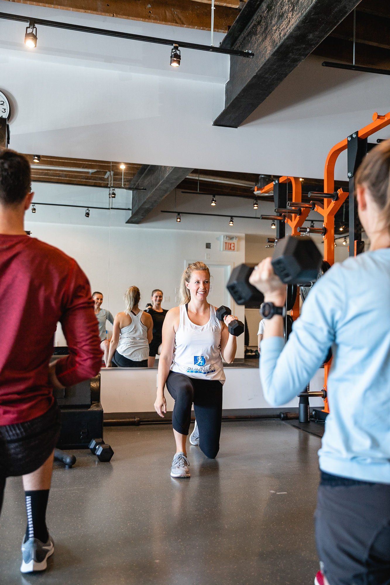 A group of men and women inside of a strength and conditioning class