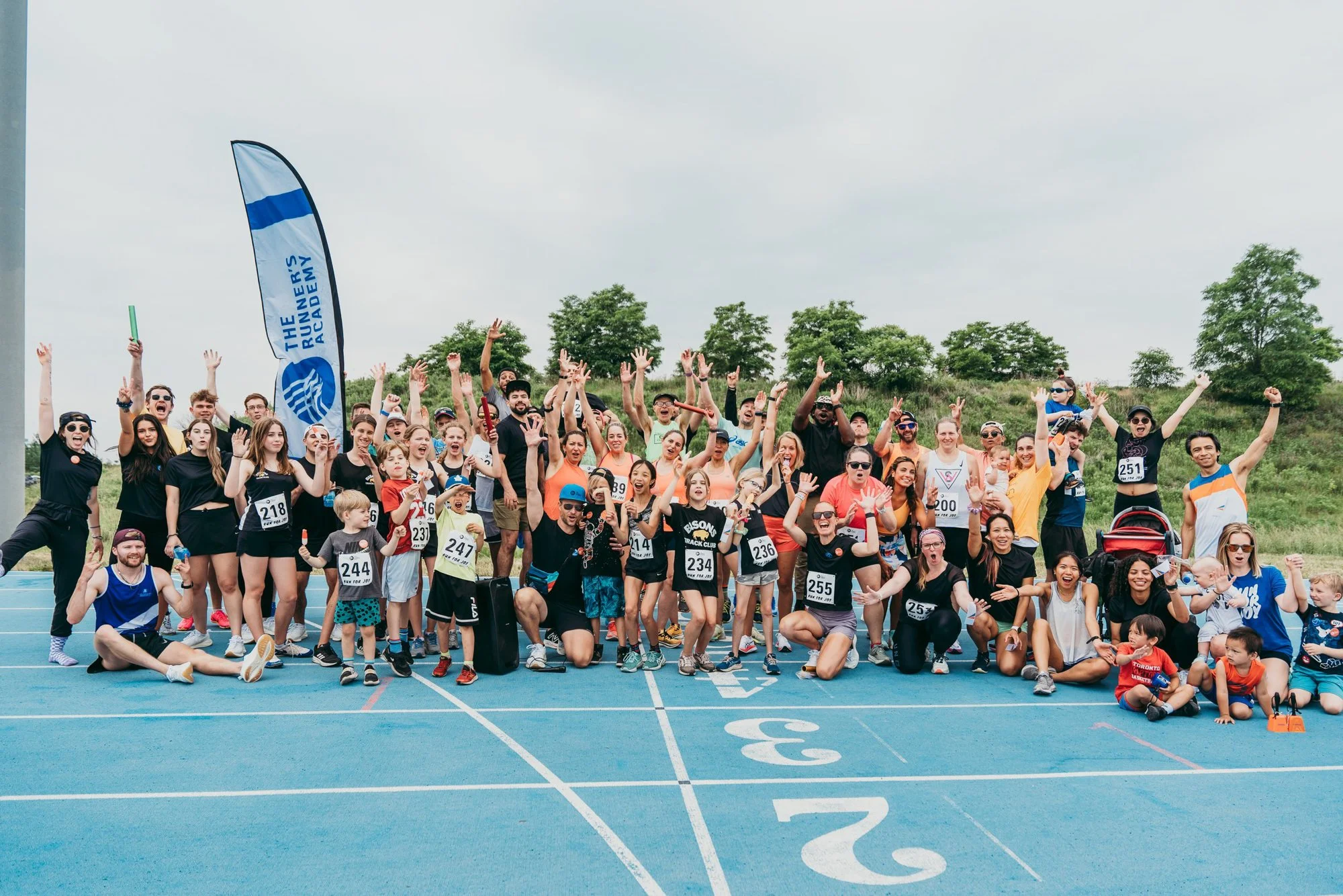 A large group of runners on a track after a race with the Runners Academy