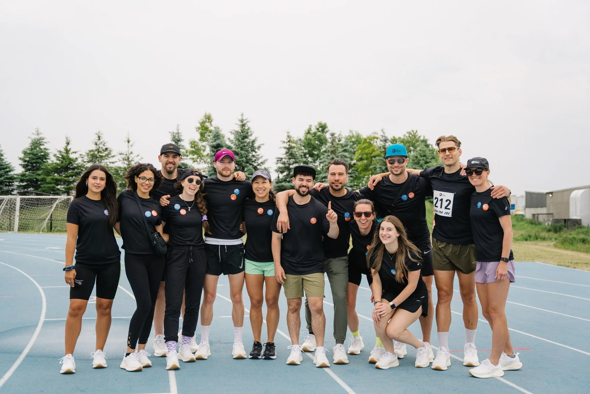 the runners academy staff posing for a group photo at a track