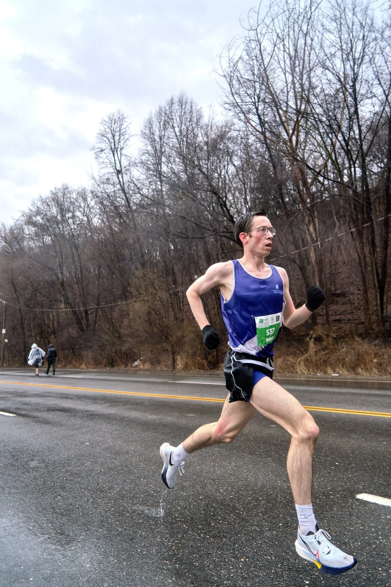 A runner running on a wet road.