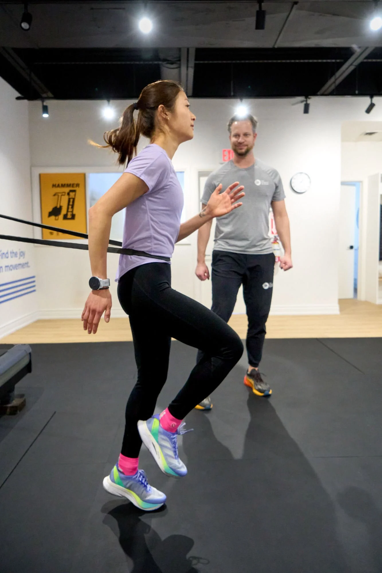 A physiotherapist working with a runner using body weight support to assist with optimizing run form
