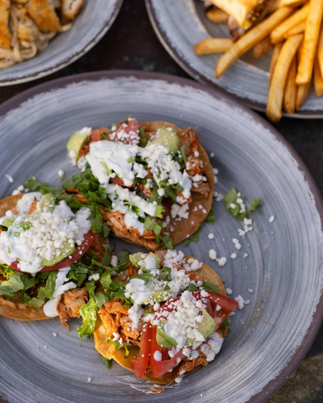 On Tuesdays in December, chicken tinga tostadas are on the menu Three per order, these crispy corn tortillas are topped with shredded chicken, lettuce, tomato, avocado, cilantro, crema &amp; queso fresco for $16.99. Try 'em while they're here! 😋