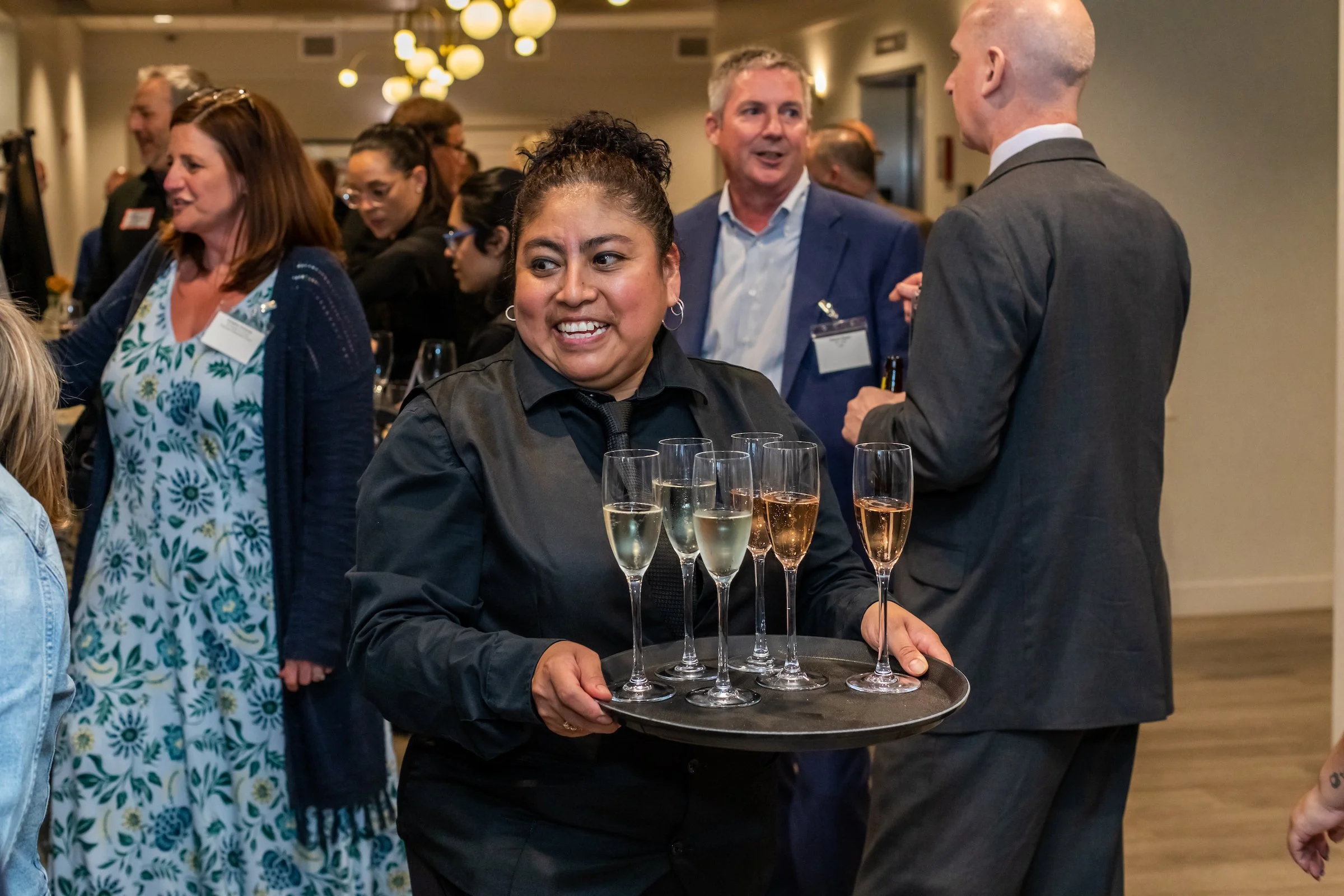 Server with a tray of sparkling wine at an event.