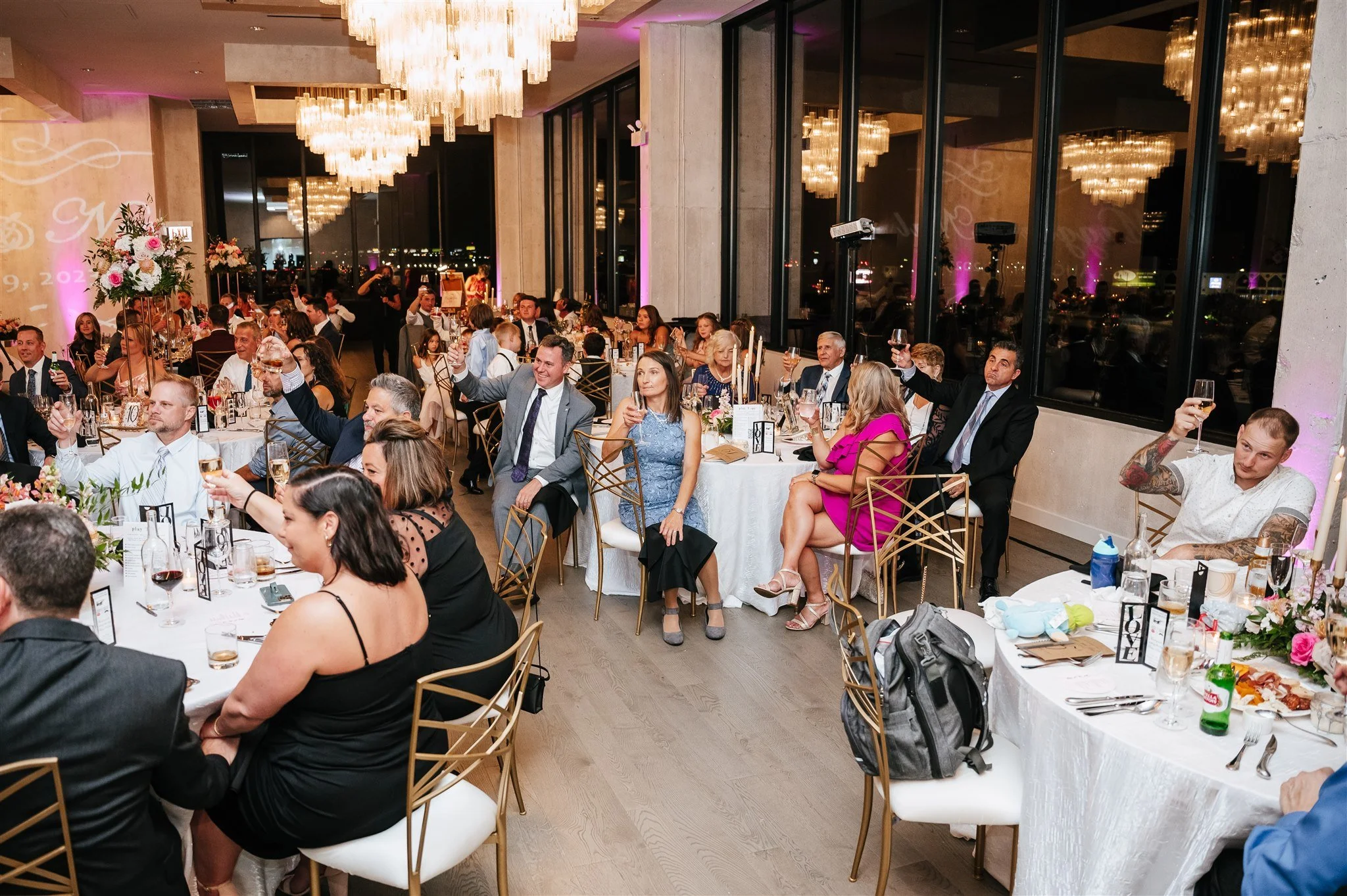 guests-sitting-at-round-dinner-tables-cheersing-champagn