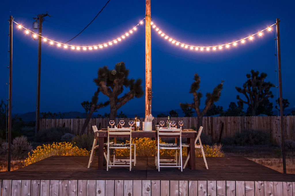outdoor stage set with dining table and party lights