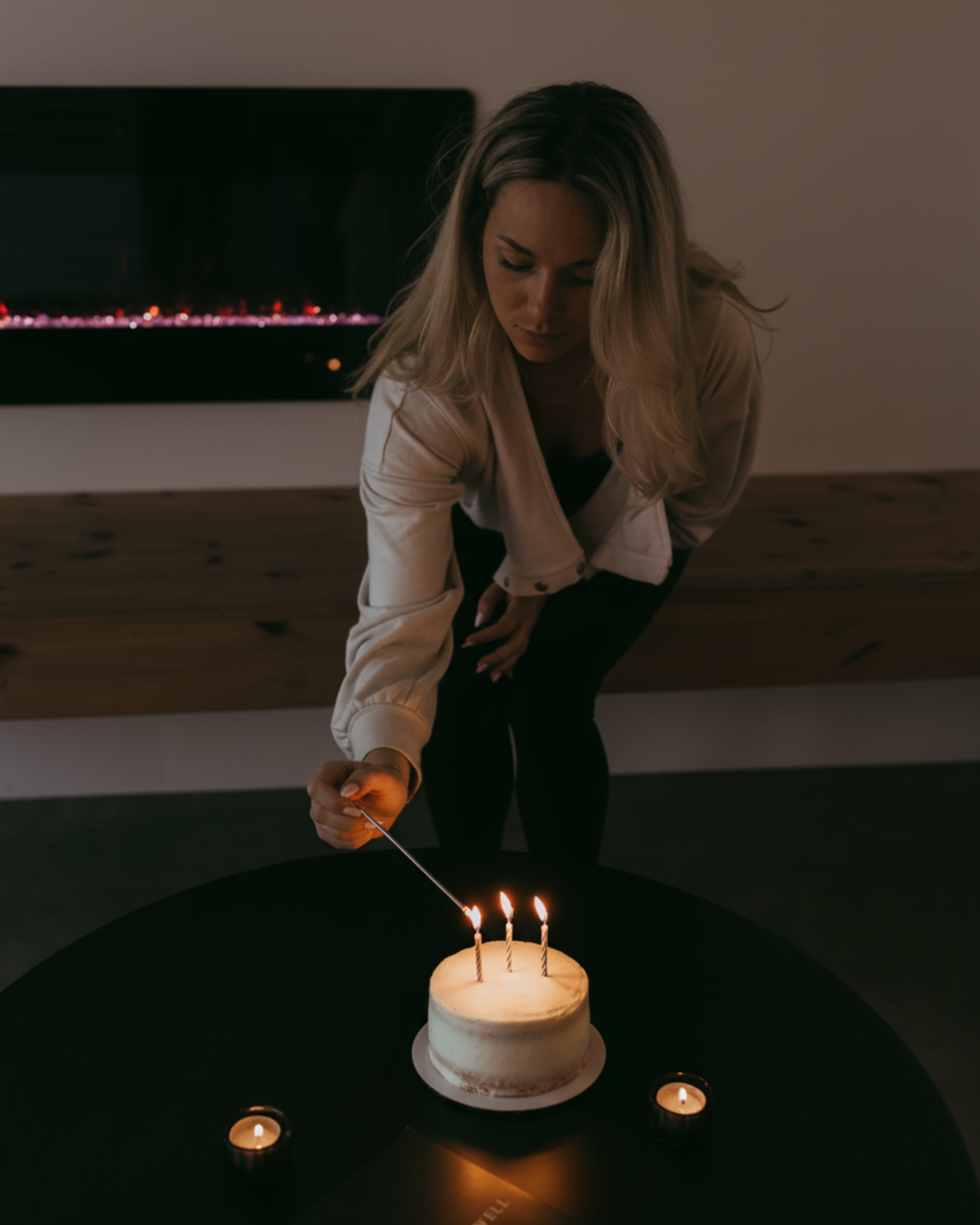 A client at recover well in norton commons lights 3 candles on a birthday cake