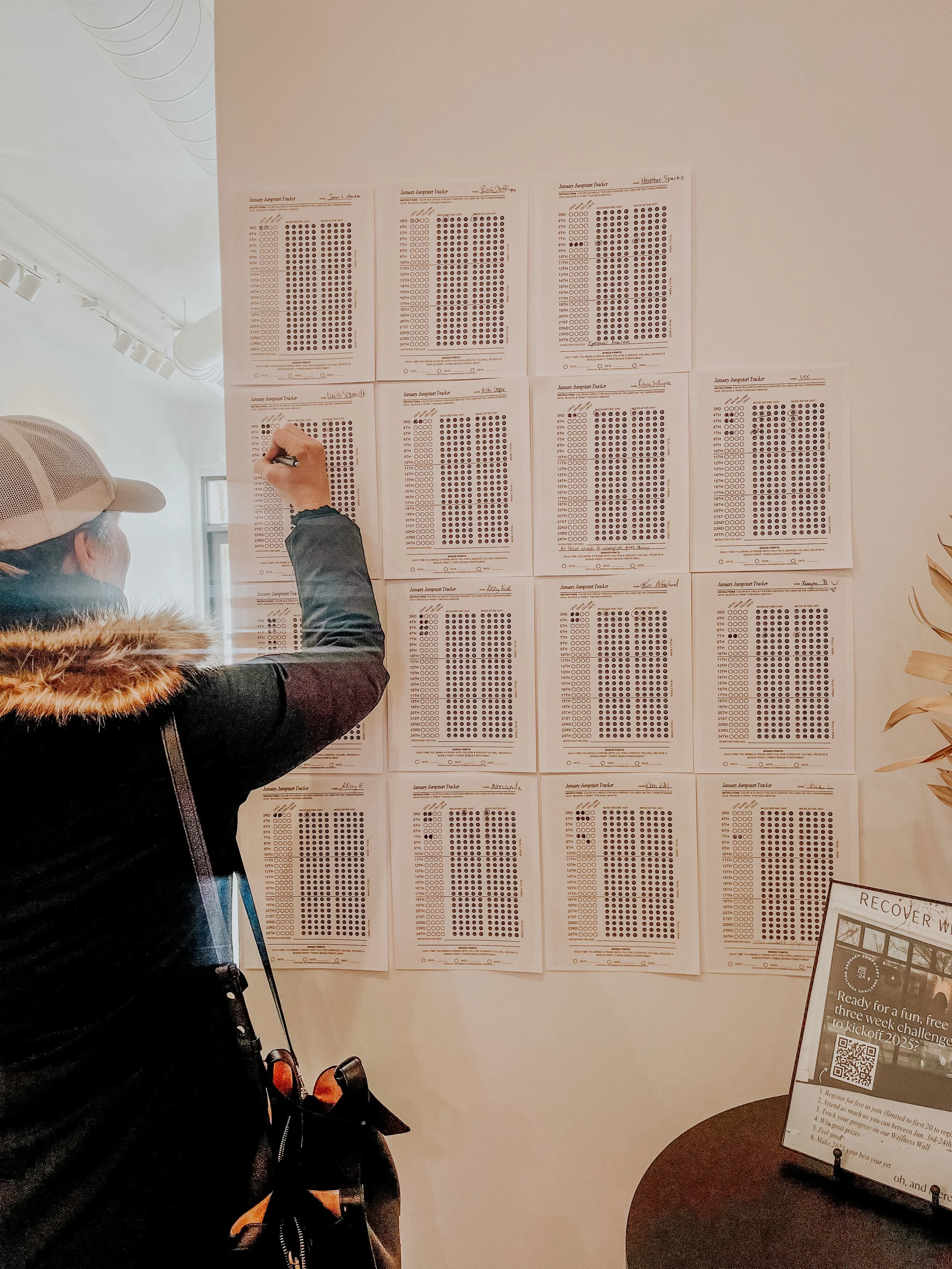 A woman lying on her back enjoying an infrared sauna pod, illuminated by blue light.