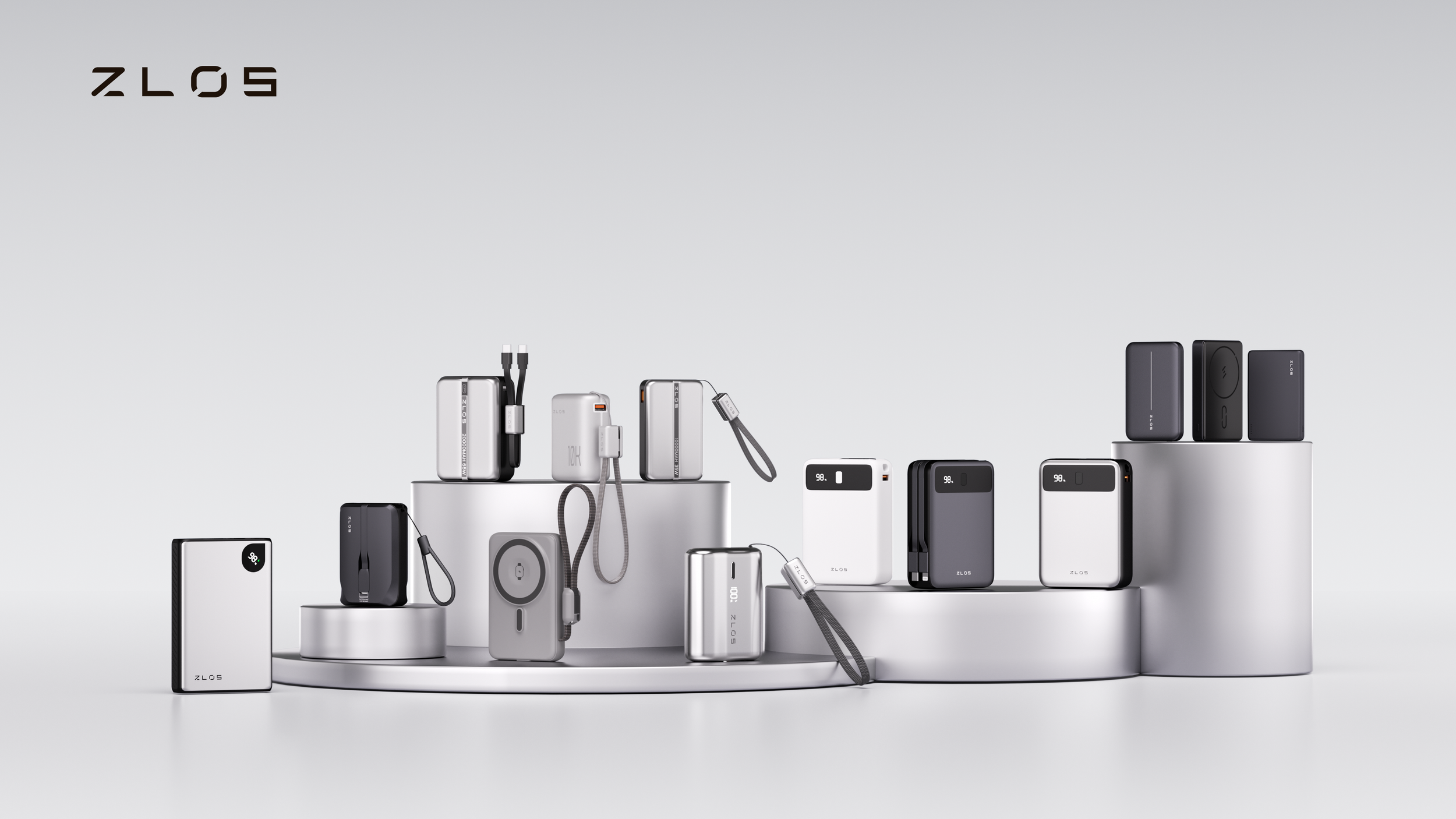 A collection of portable power banks and chargers in black, gray, and white, displayed on white cylindrical pedestals with the brand name ZLOS visible on some of the devices.