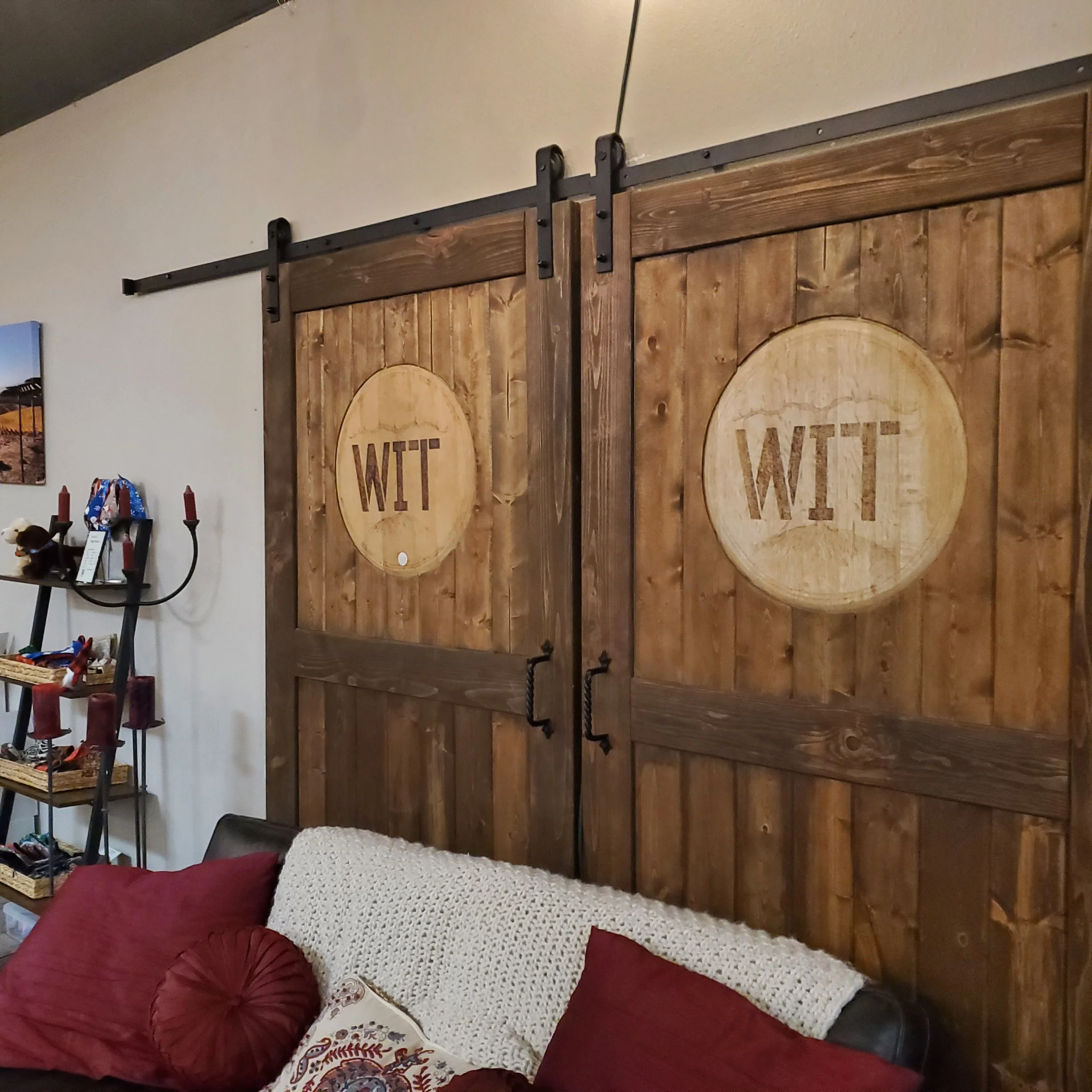 A pair of barn-style doors with "WIT" emblazoned on them inside the WIT tasting room.