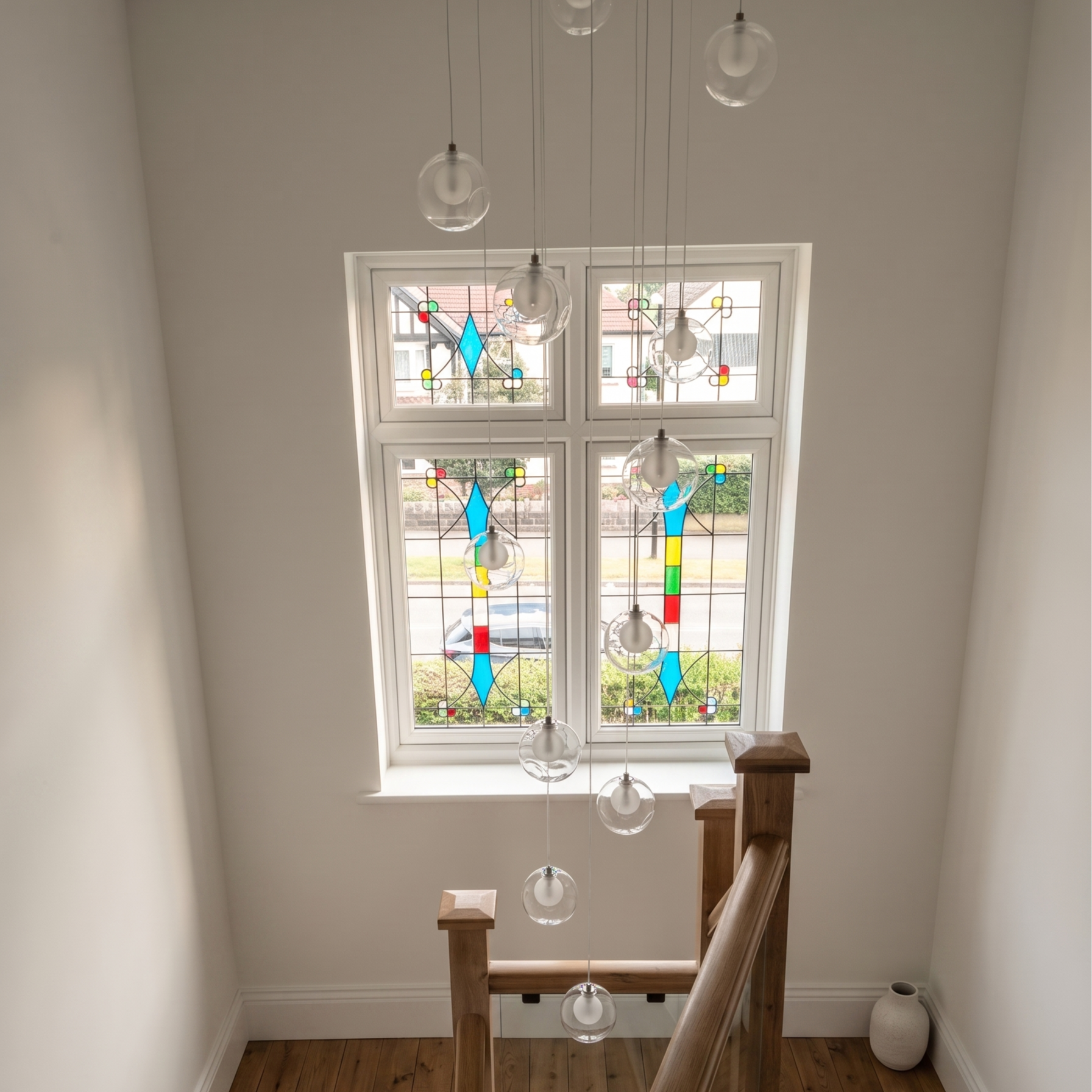 Renovated staircase featuring custom integrated accent lighting and replacement flush sash windows with traditional stained glass detailing.