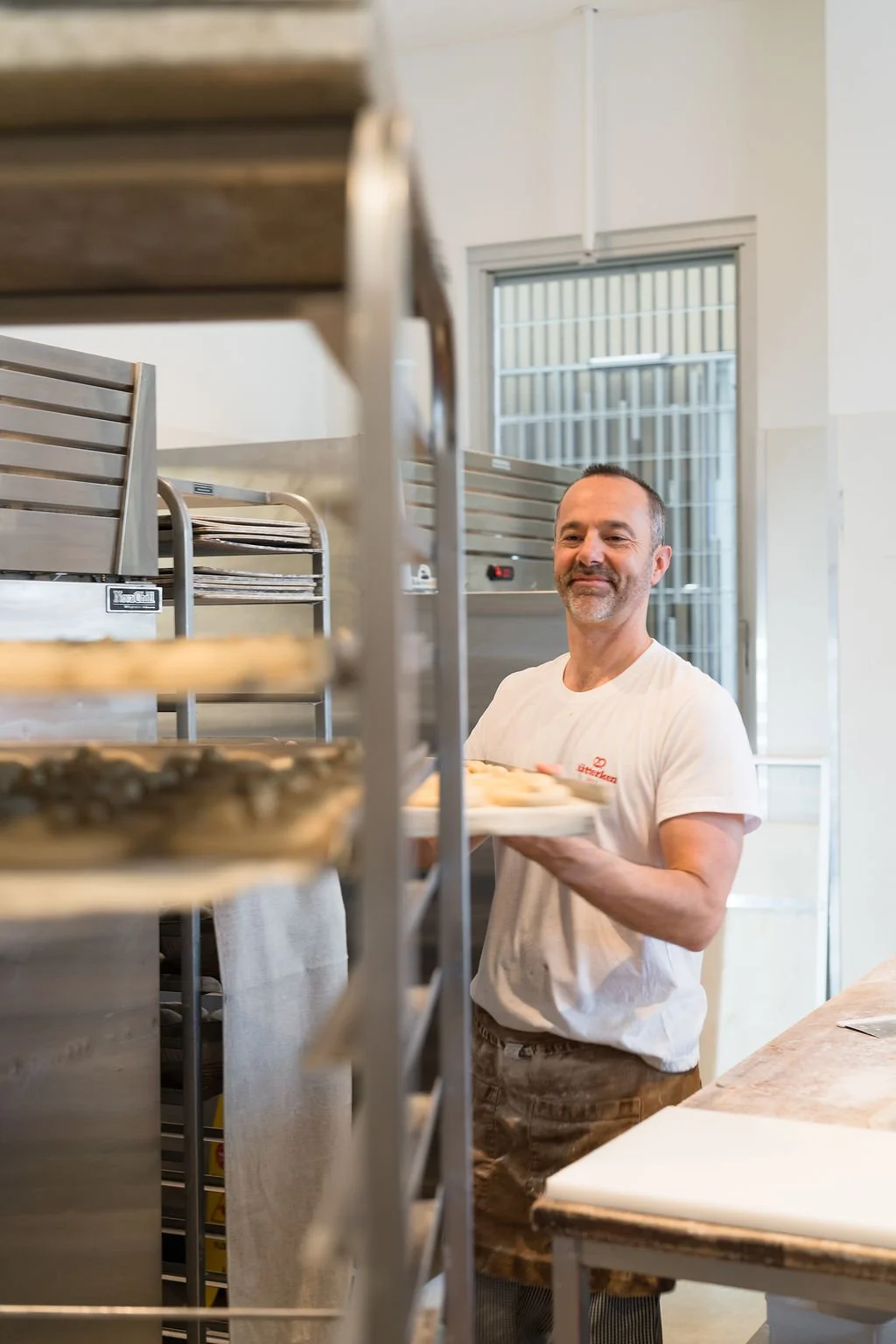 Bread roll shaped like a smiling face with pretzel arms.